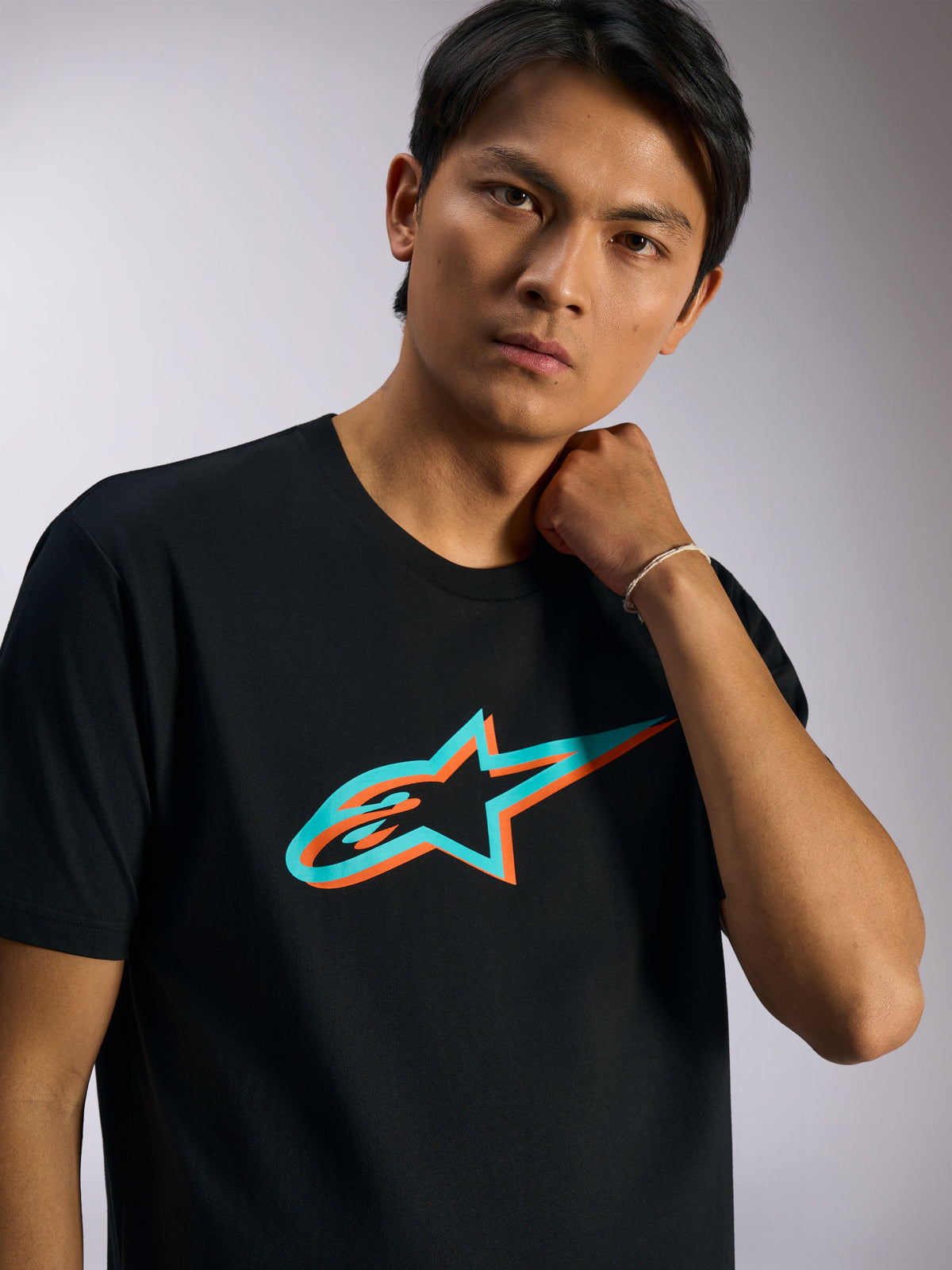 Alpinestars Ageless Shadow CSF Tee, Short Sleeve T-Shirt, Black with Turquoise and Orange Shadow Logo, worn by model, casual motorsport-inspired streetwear