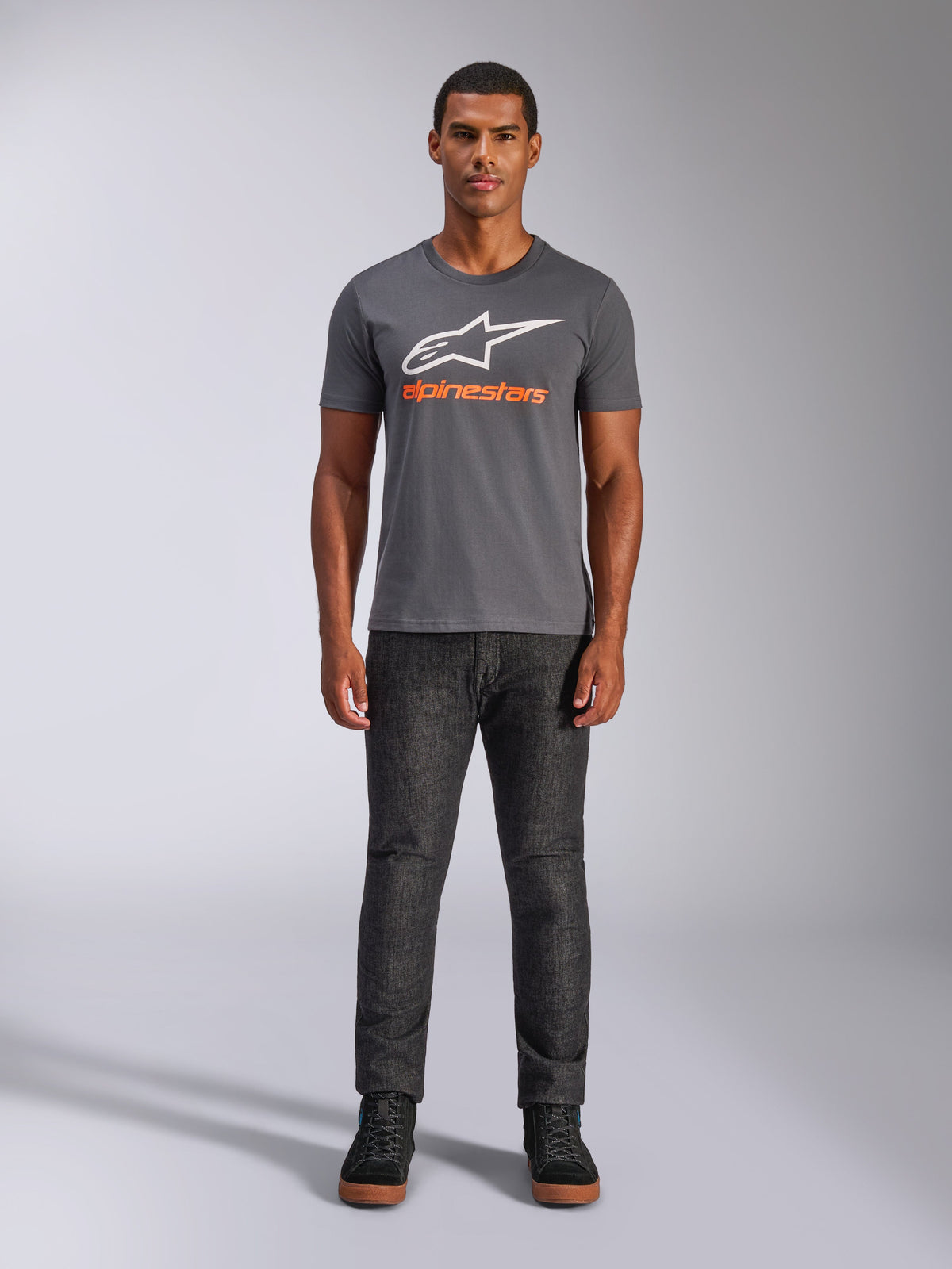 Alpinestars Always 2.0 CSF Tee, T-shirt met korte mouwen, antracietgrijs met wit logo en oranje tekst, gedragen door model met donkere jeans, casual motorsport streetwear