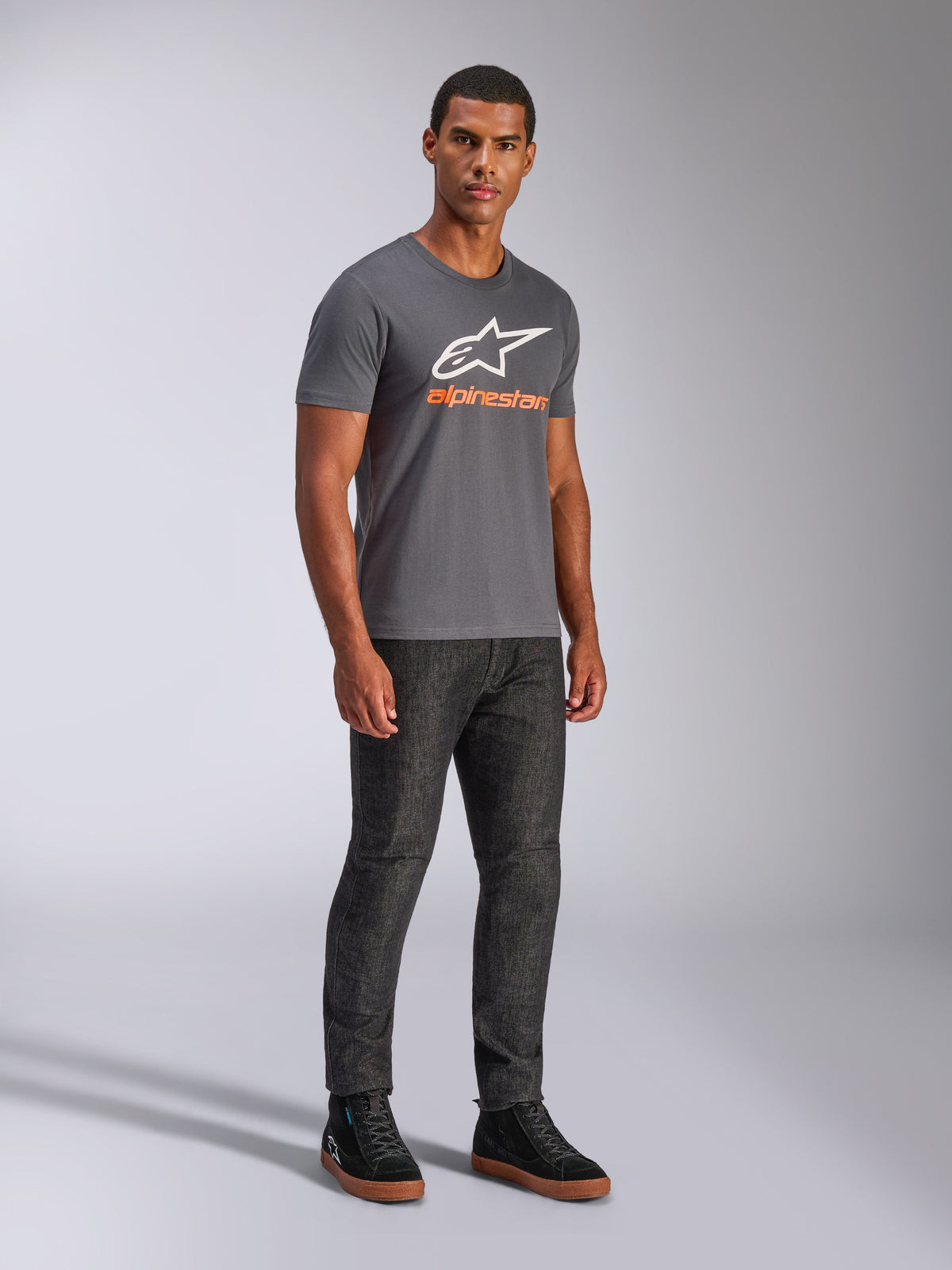 Alpinestars Always 2.0 CSF Tee, T-shirt met korte mouwen, antracietgrijs, wit A-star logo met oranje merknaam, casual motorsport streetwear gedragen met een donkere jeans en zwarte sneakers