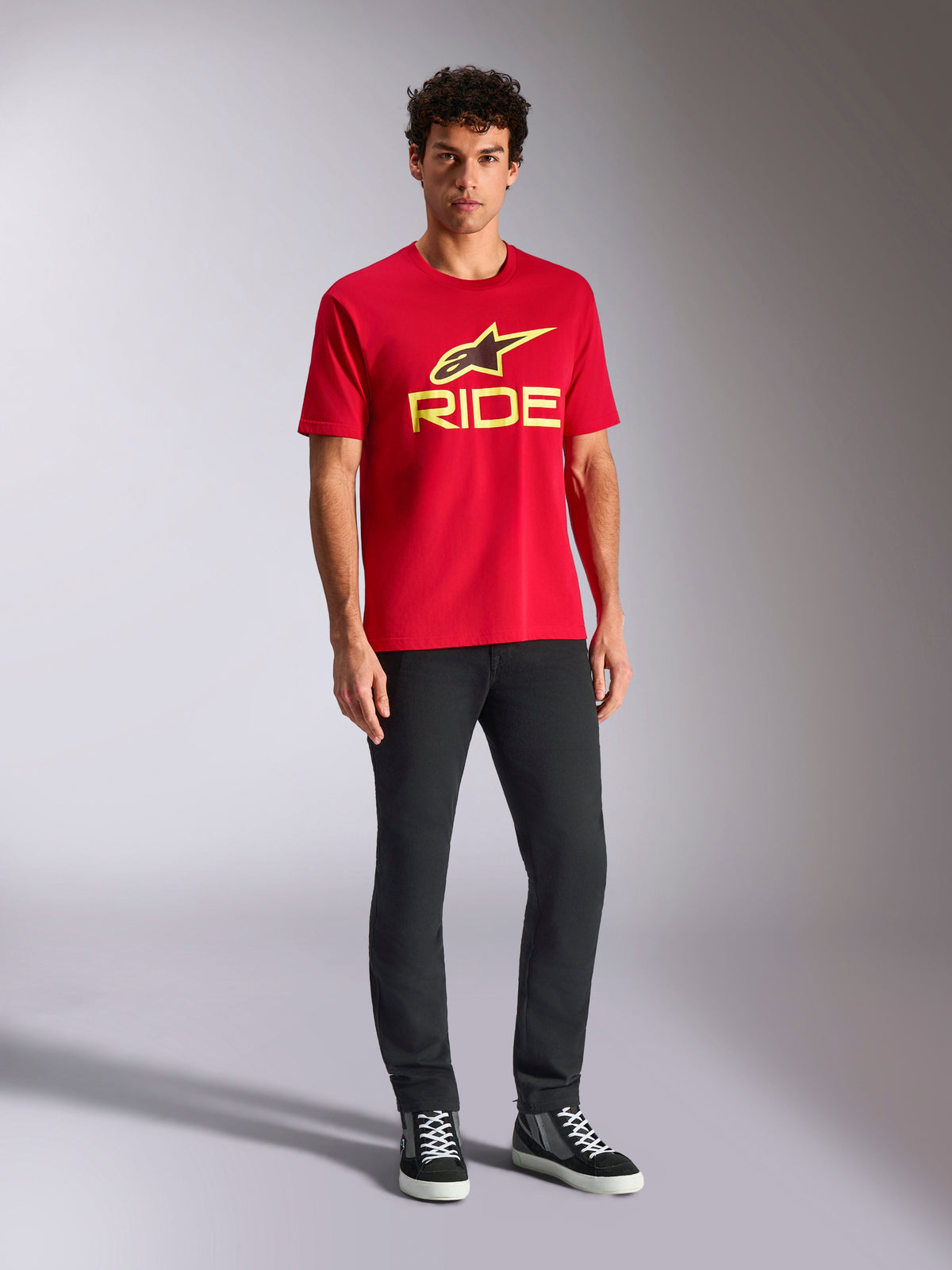 Alpinestars Ride 4.0 CSF Tee, Short Sleeve T-Shirt, Red with Hi-Vis Yellow Alpinestars Star and Ride Logo, worn by model with black pants and sneakers, Casual Motorsport Sportswear