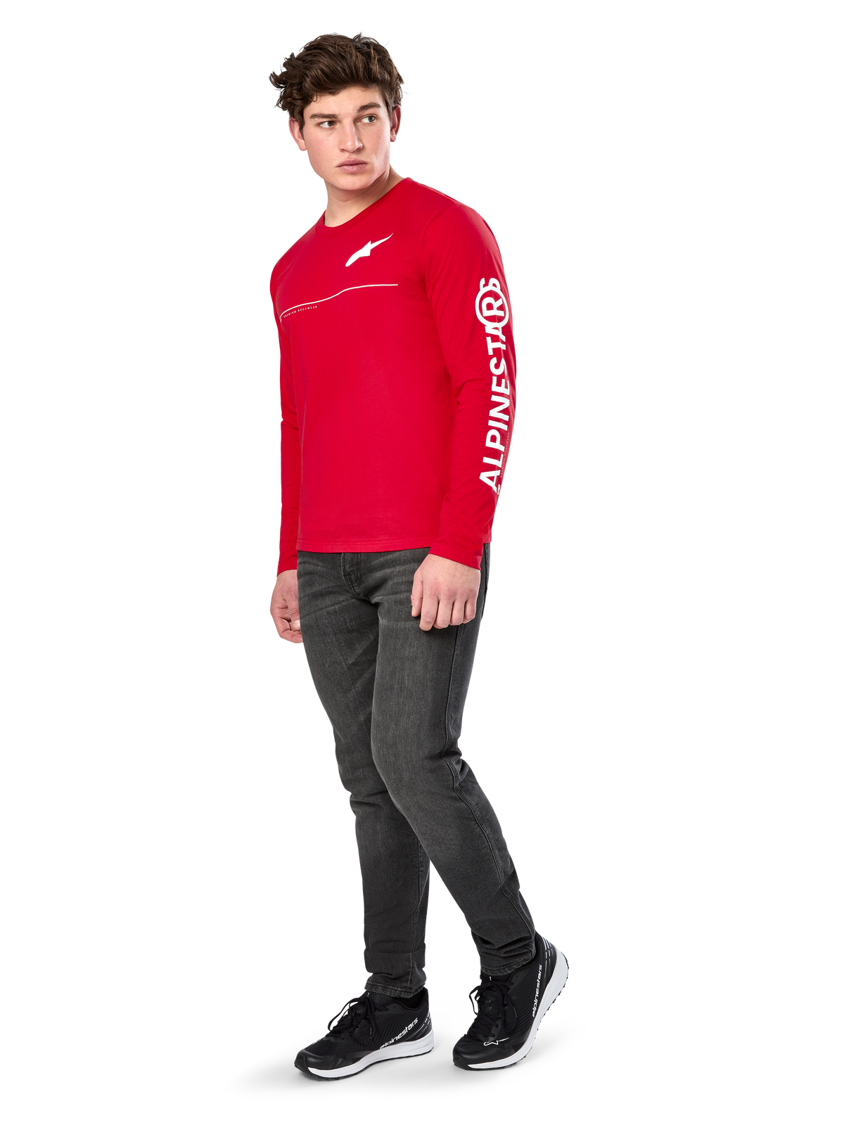 Alpinestars Committed CSF Tee, T-shirt met lange mouwen, rood, met wit Astars-logo op de borst en Alpinestars-branding op de mouw, gedragen door een model met donkere jeans en zwarte sneakers, casual motorsport streetwear
