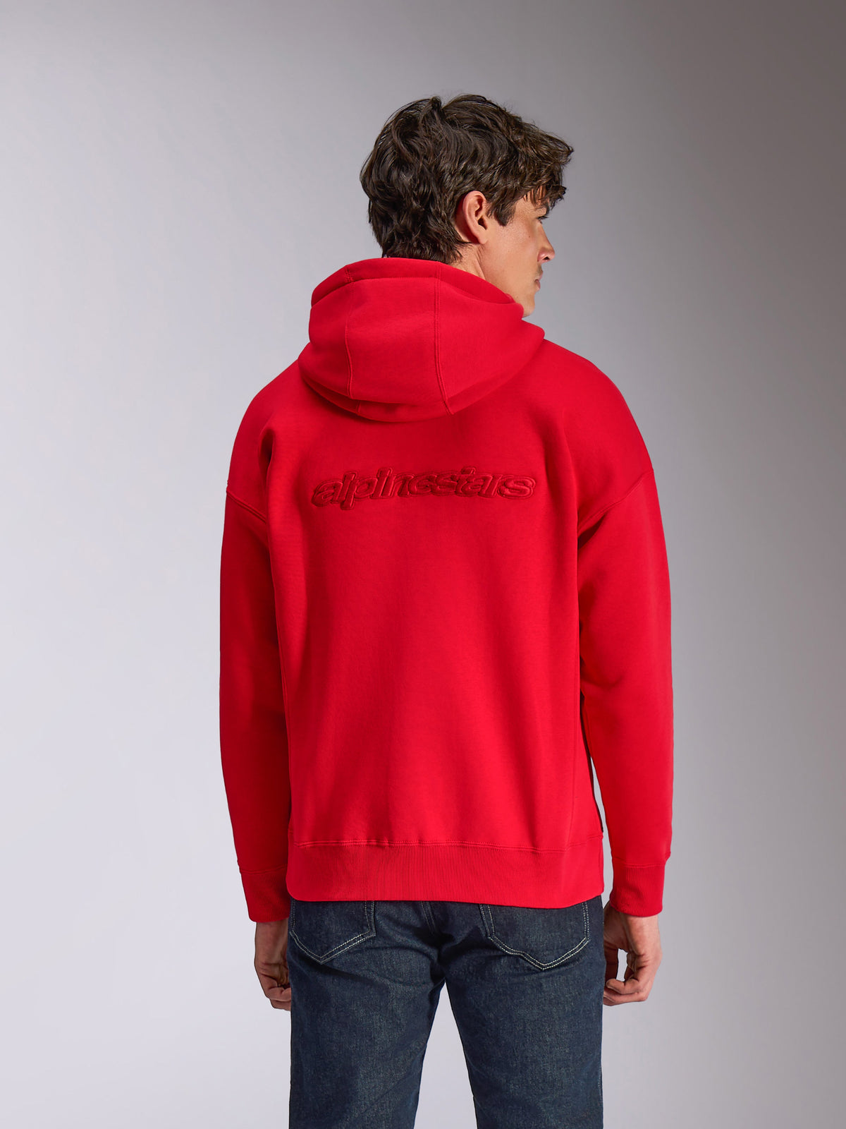 Alpinestars Emergent Oversized Hoodie, rood, achteraanzicht op model, met ton-sur-ton 3D-geborduurd Alpinestars-woordlogo, oversized pasvorm met geribbelde zoom en manchetten, casual motorsport-geïnspireerde streetwear