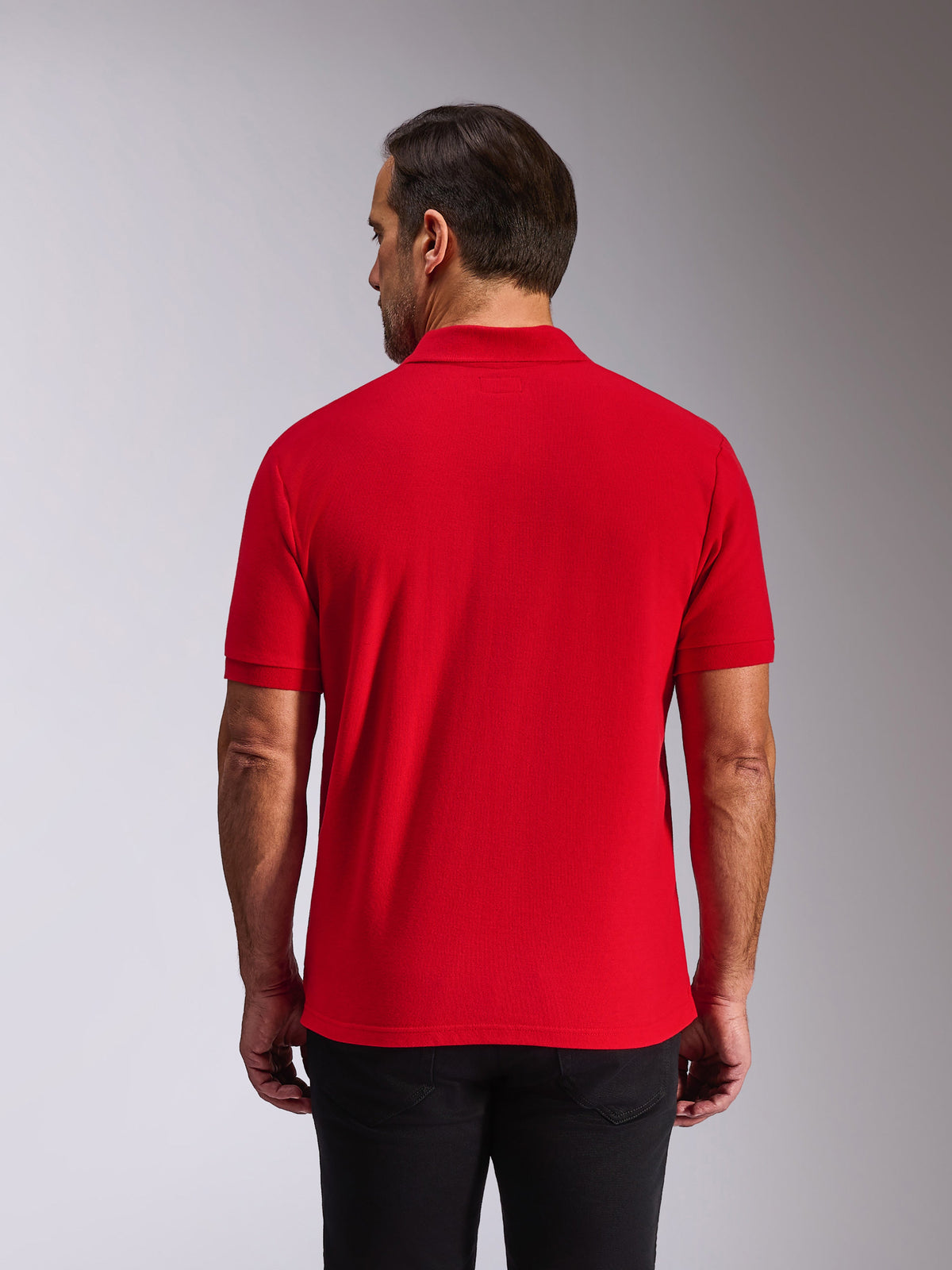 Alpinestars Endeavor Classic Polo, poloshirt met korte mouwen, rood, achteraanzicht op model, met geribde kraag en manchetten, casual motorsport-geïnspireerde streetwear