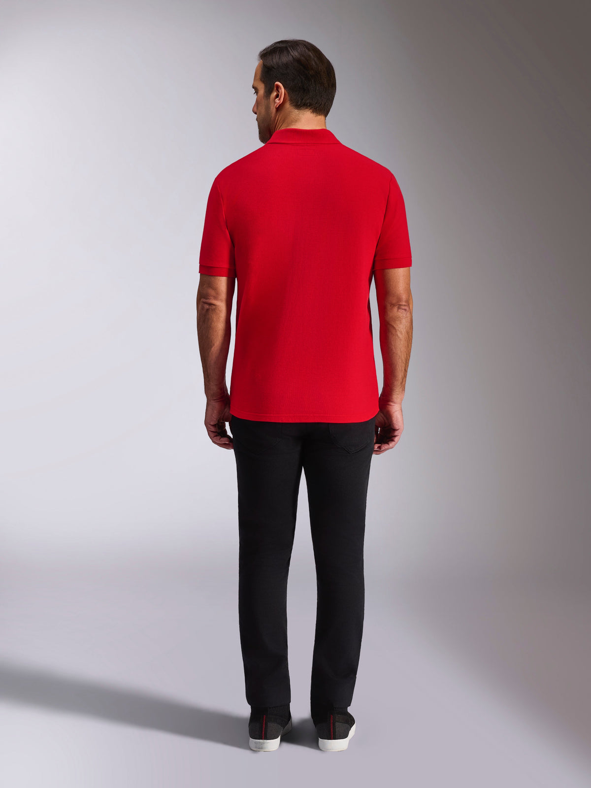 Alpinestars Endeavor Classic Polo, rood piqué poloshirt, achteraanzicht, gedragen met een zwarte broek, casual motorsport streetwear met geribde kraag en manchetten