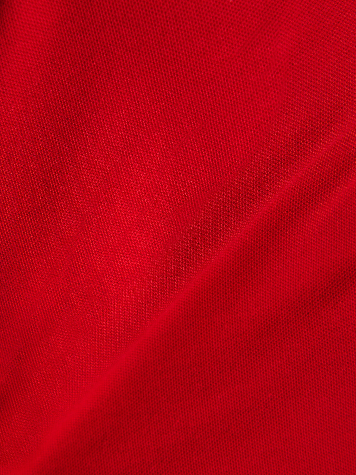 Alpinestars Endeavor Classic Polo, detailopname van rode piqué stof, getextureerd gebreid materiaal, katoen-polyester mix, casual motorsport sportkleding