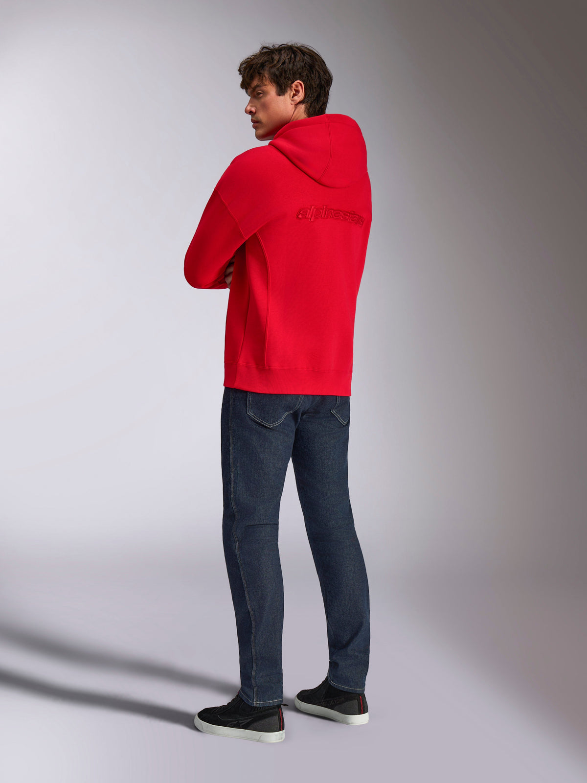 Alpinestars Emergent Oversized Hoodie, rood, achteraanzicht met geborduurd Alpinestars-woordlogo op de rug, oversized pasvorm, gedragen met donkerblauwe jeans en zwarte sneakers, casual lifestyle streetwear