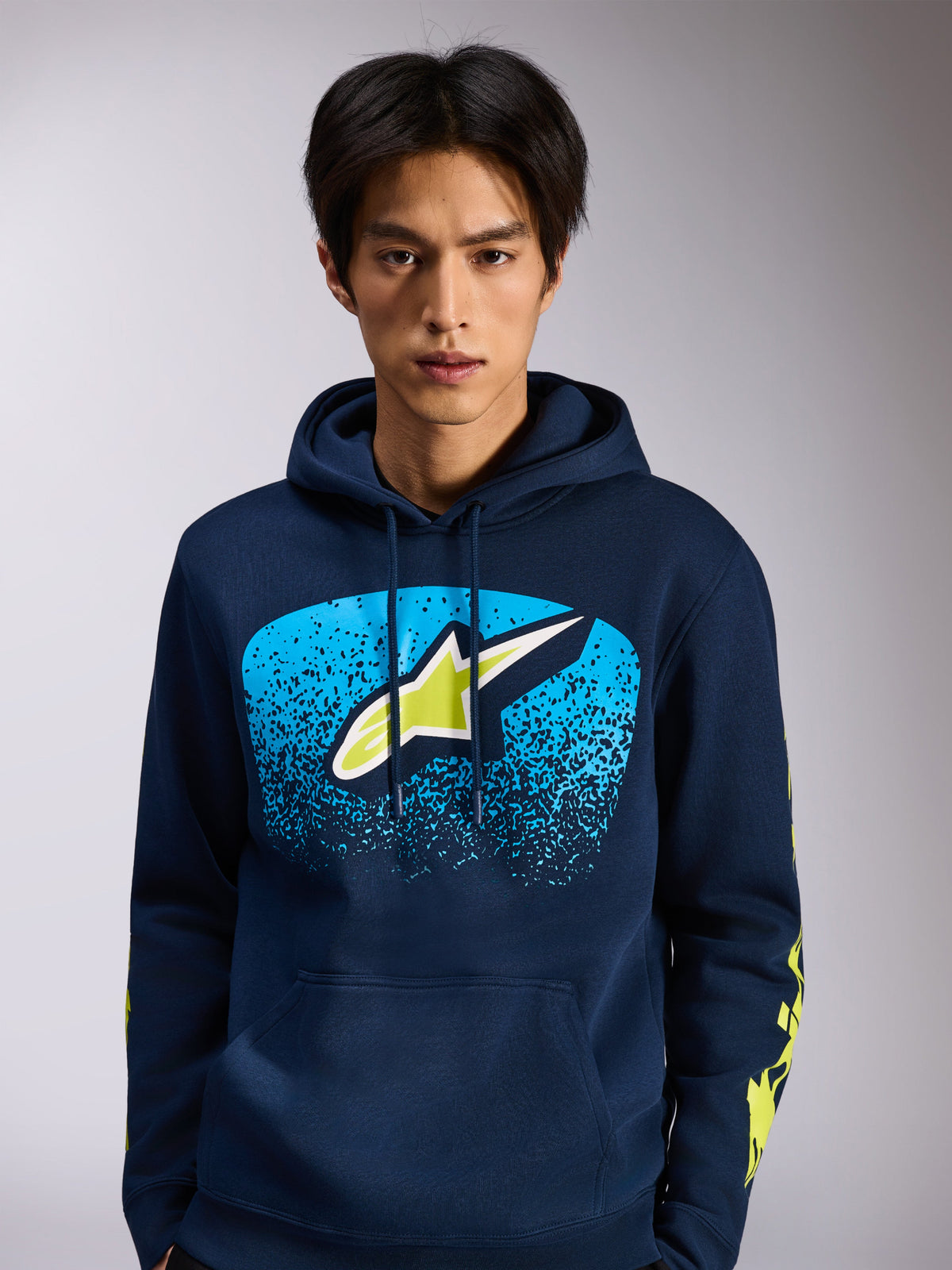Alpinestars Obsessed Hoodie, donkerblauwe fleece pullover, Astars-logo op de voorzijde met blauw MX-verloop en limegroene accenten, gele woordlogo's op de mouwen, casual motorsport-geïnspireerde streetwear