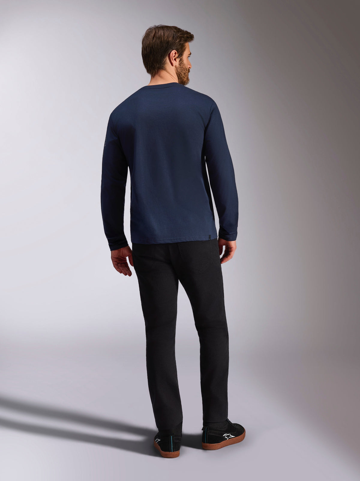 Alpinestars Mandatory CSF T-shirt met lange mouwen, navy blauw, achteraanzicht, gedragen met een zwarte broek, casual motorsport-geïnspireerde streetwear