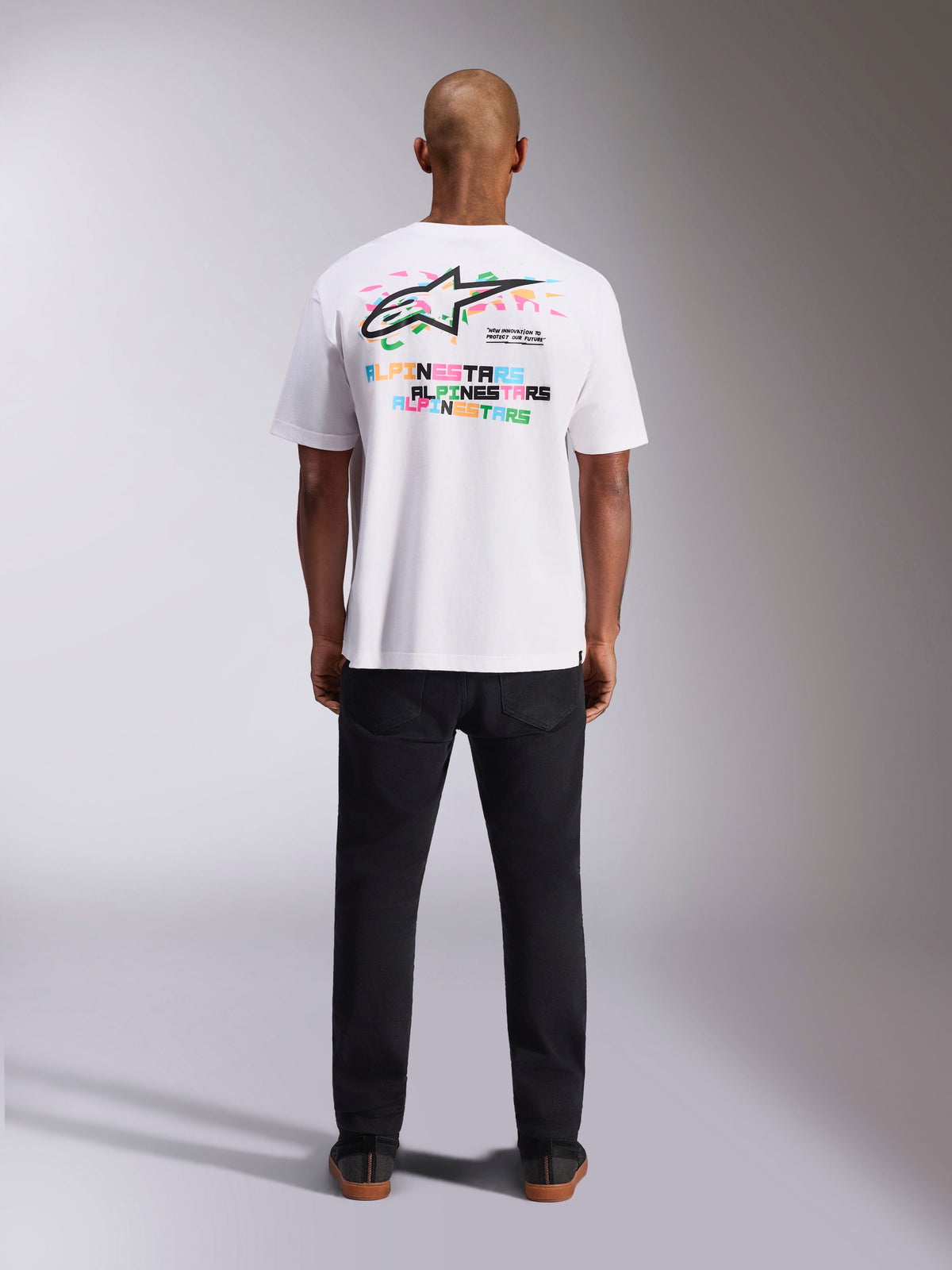 Alpinestars Wild Oversized CSF Tee, T-shirt met korte mouwen, wit, achteraanzicht met levendig meerkleurig Astars-logo en herhaalde typografie, casual motorsport-geïnspireerde streetwear
