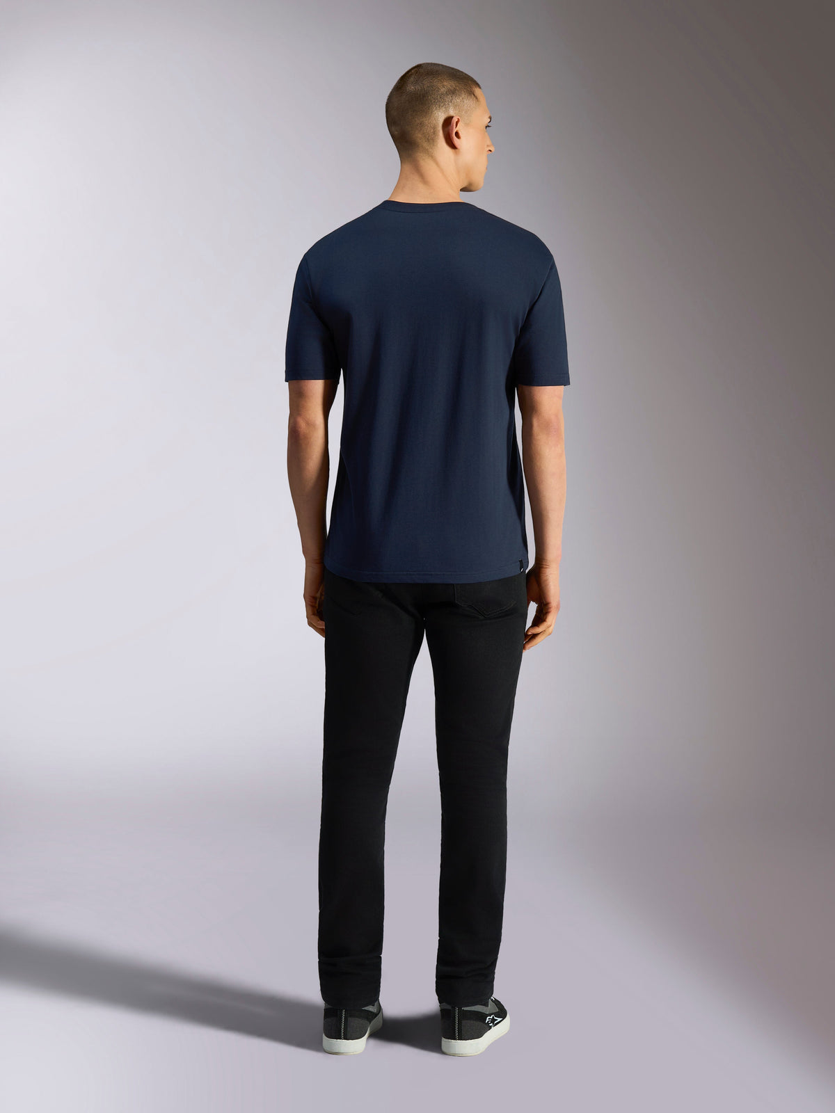 Alpinestars Noka CSF Tee, Short Sleeve T-Shirt, Navy Blue, rear view of a man wearing the t-shirt paired with black pants and sneakers, casual motorsport streetwear