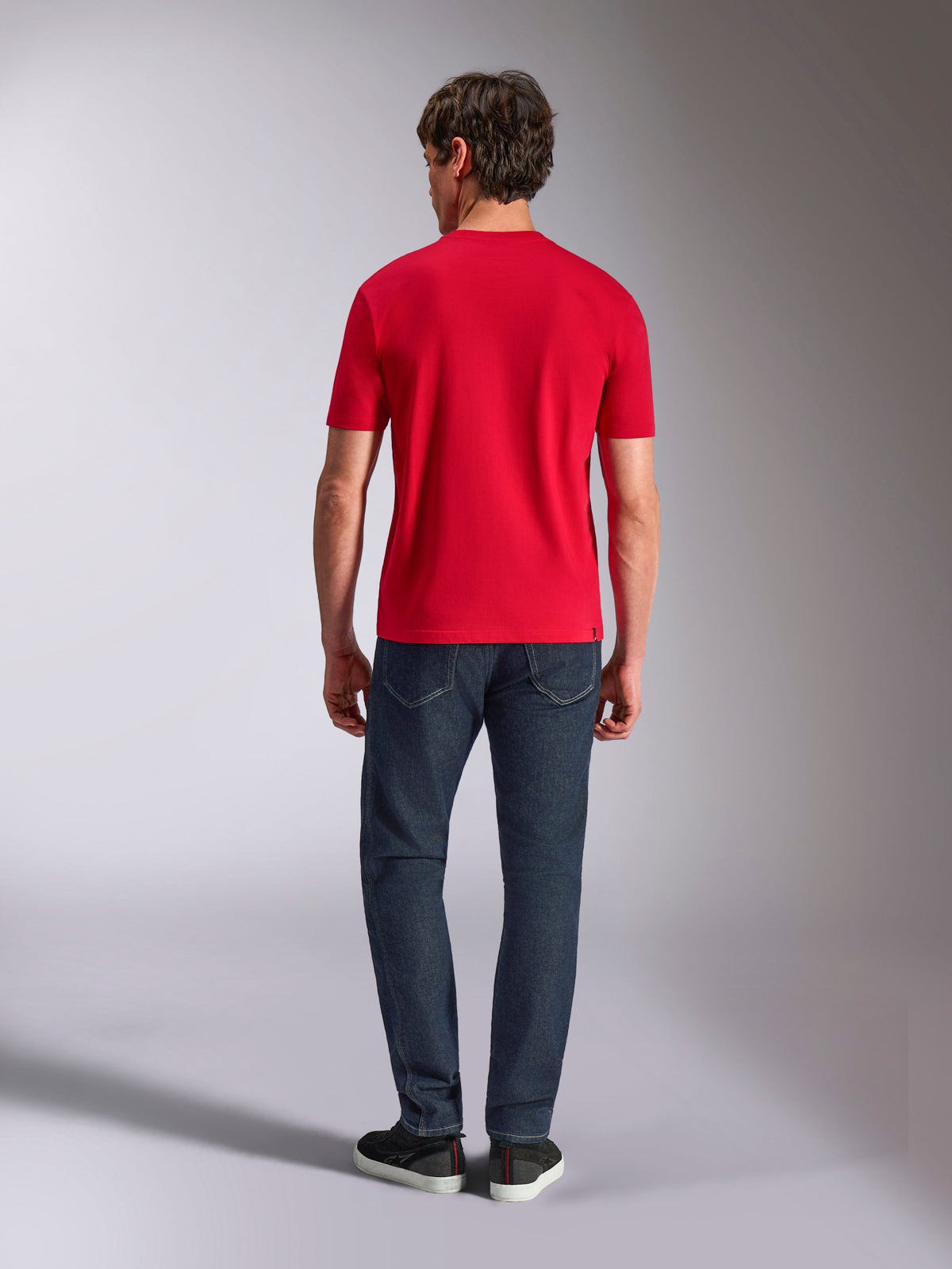 Alpinestars Authority CSF Tee, T-shirt met korte mouwen, rood, achteraanzicht op een model in een donkerblauwe jeans en zwarte sneakers, casual motorsport-geïnspireerde streetwear