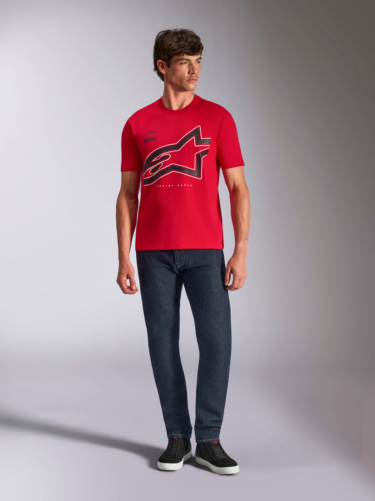 Alpinestars Authority CSF Tee, T-shirt met korte mouwen, rood, groot zwart gecropt Astars-logo met witte omtrek, gedragen met donkerblauwe jeans en zwarte sneakers, casual motorsport-geïnspireerde streetwear