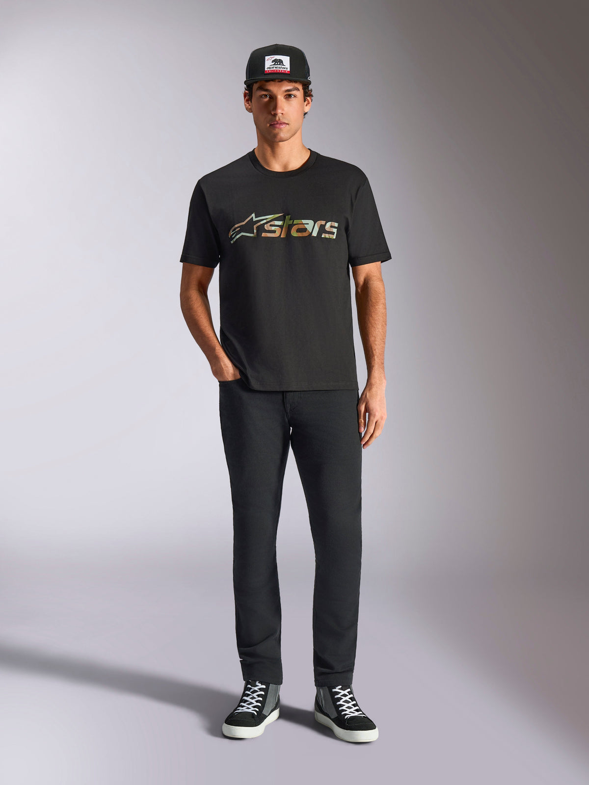 Alpinestars Verdure Camo CSF Tee, Short Sleeve T-Shirt, Black, featuring a camouflage pattern Astars logo on the chest, worn by a model with a black cap and black pants, Casual Motorsport Streetwear