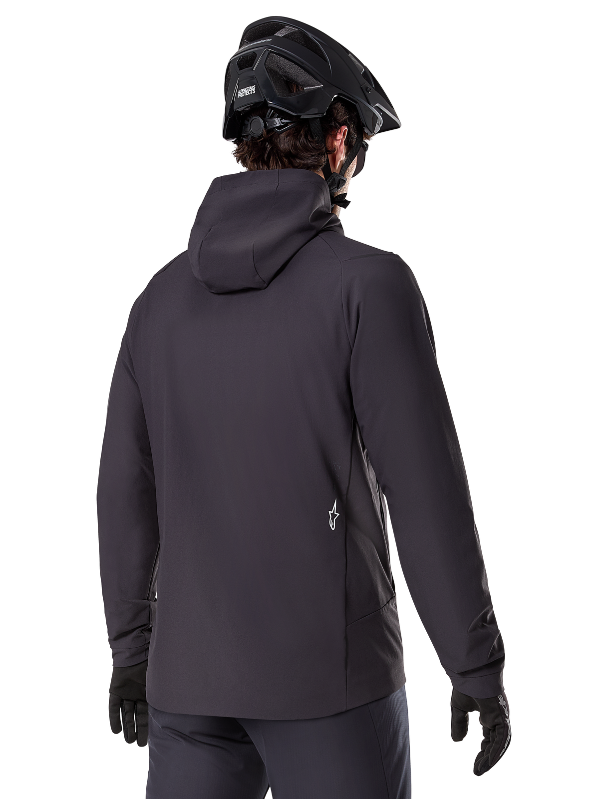 Alpinestars A-Dura Thermal Jacket, zwart, achteraanzicht, gedragen met een zwarte mountainbikehelm en handschoenen, voorzien van een klein wit Astars-logo op de onderrug, lichtgewicht geïsoleerde fietsjas