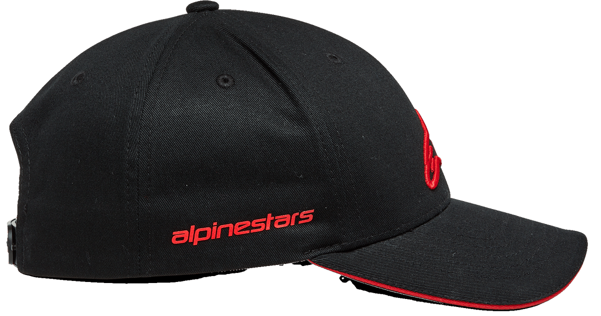 Alpinestars Rostrum pet, snapback cap met gebogen klep, zwart en rood, zijaanzicht met rood Alpinestars woordmerk, gestructureerde kroon en rode sandwich-rand aan de klep, op motorsport geïnspireerde hoofdbedekking