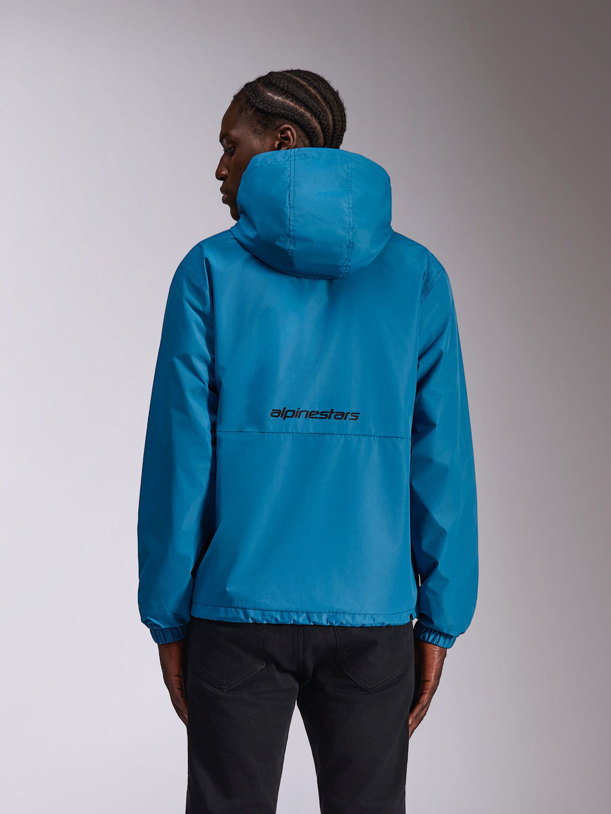 Alpinestars Speeder Chromium Windbreak Jacket, Blue, rear view on model showing black wordmark logo on the back, lightweight hooded windbreaker with elastic cuffs, casual sportswear.