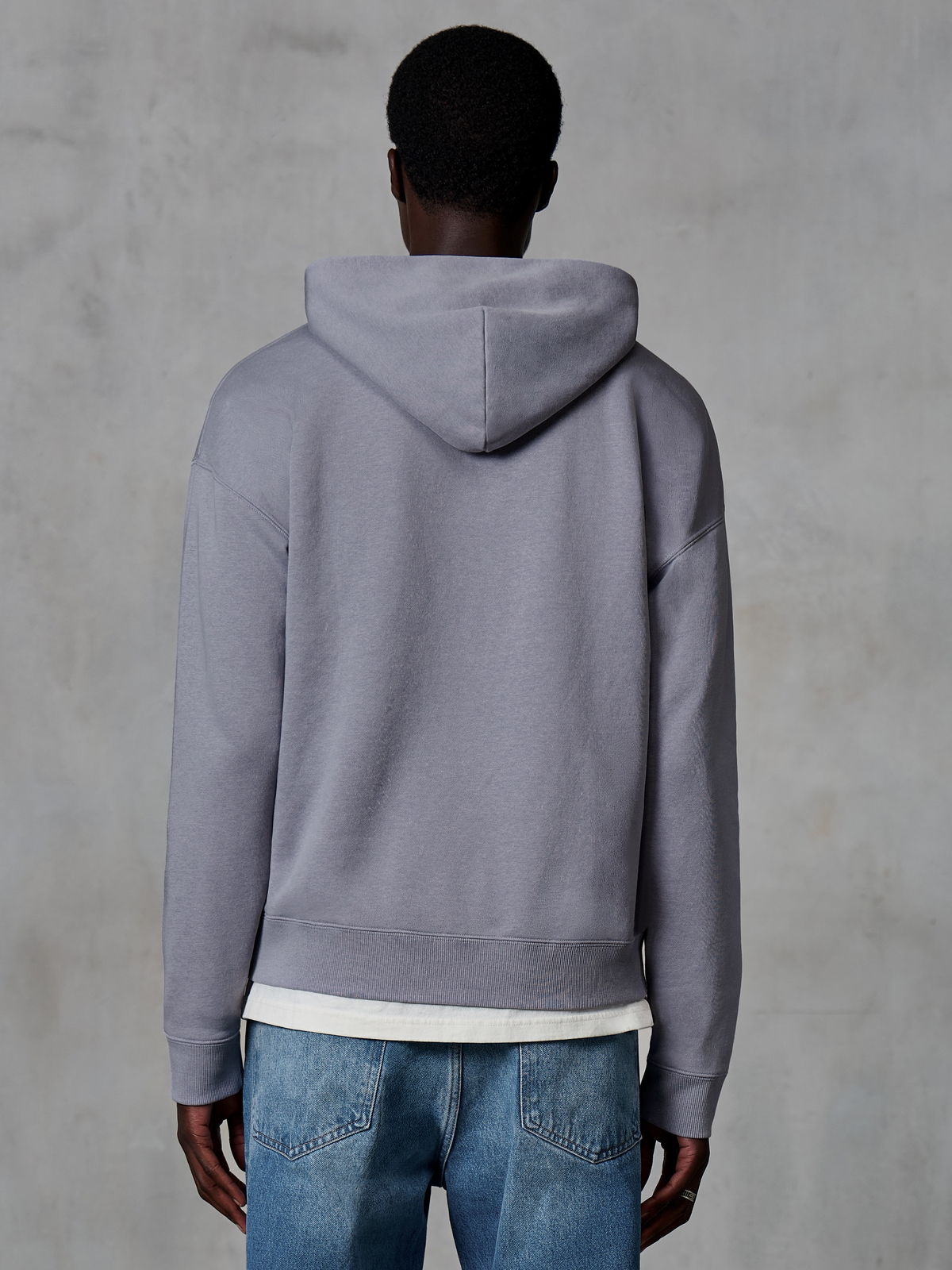 Alpinestars Essentials Ageless Zip Hoodie, zilver, achteraanzicht, casual streetwear, ontspannen pasvorm met garment stone wash-afwerking, gecombineerd met blauwe jeans en wit ondershirt