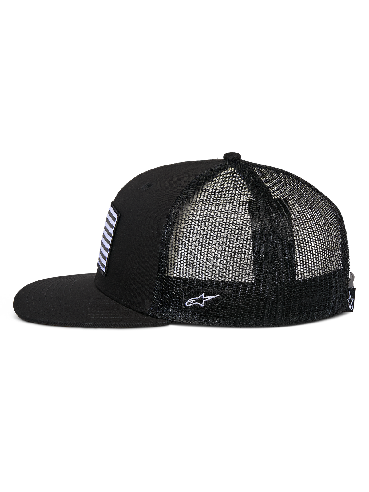 Alpinestars Flag Flat Trucker pet, zijaanzicht, zwart, platte klep en gestructureerde kroon, ademende polyester mesh achterzijde, vlagpatch aan de voorzijde en wit geborduurd logo aan de zijkant, casual motorsport-geïnspireerde pet