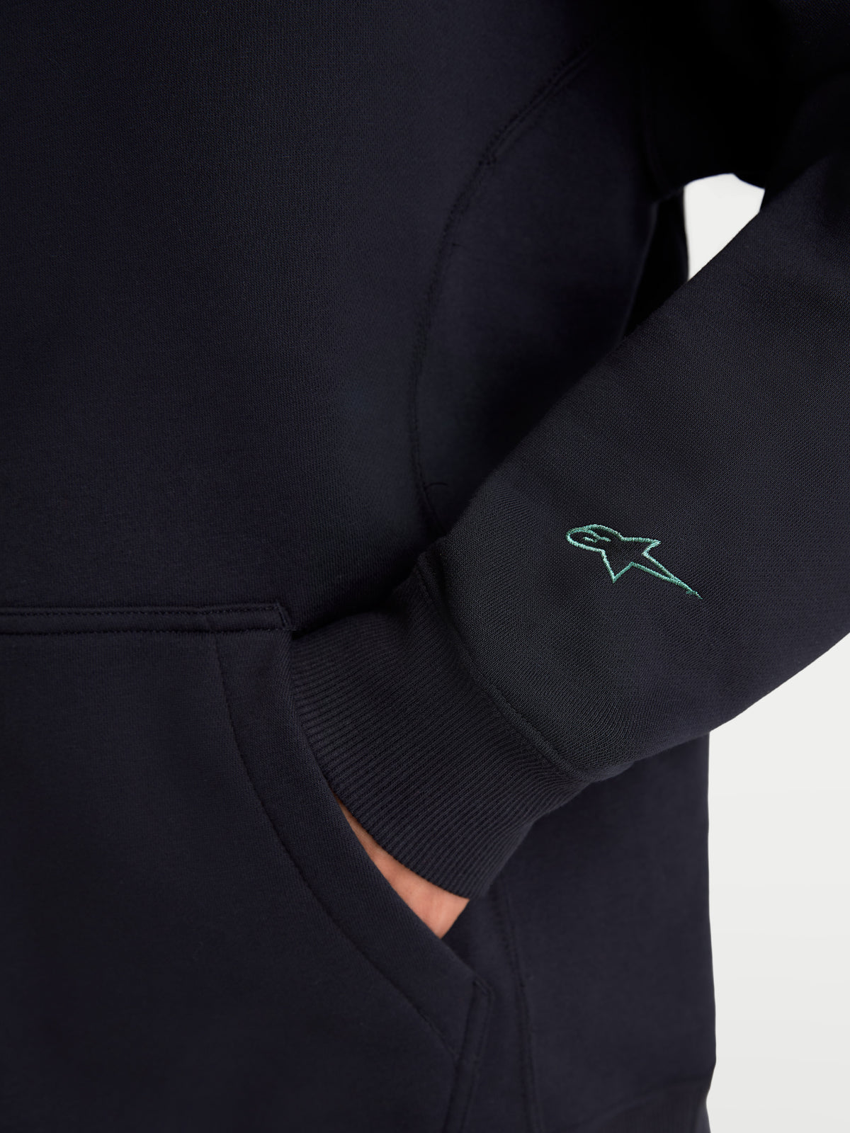 Alpinestars Guise Oversized Crew, sportswear fleece pullover, zwart, detail van het geborduurde Astars-logo op de mouw, geribde manchetten en kangoeroezak, mix van katoen en gerecycled polyester, relaxte oversized pasvorm.