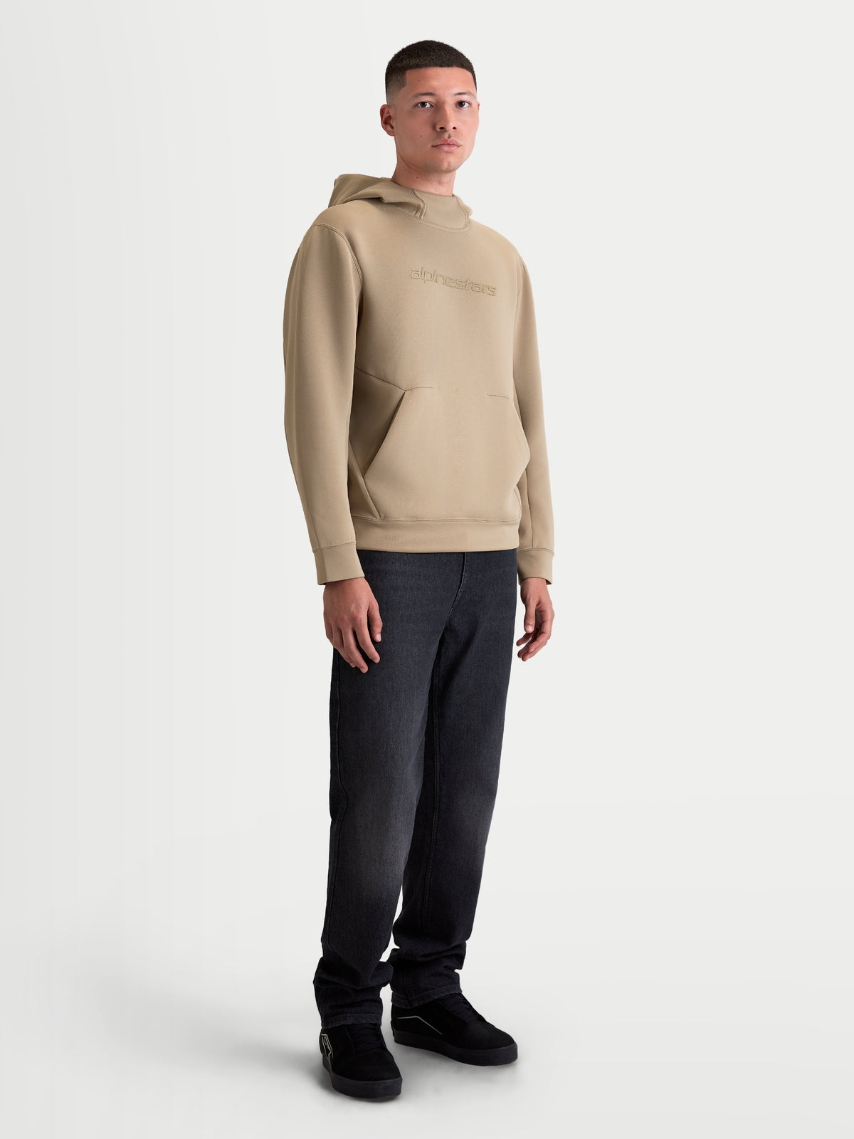 Alpinestars Datrix hoodie, heren sportswearpullover, bruin, voorzien van tonale HD-branding, een capuchon met meshvoering en een voorzak met dartdetail, getoond op een model voor een casual motorsportstijl.