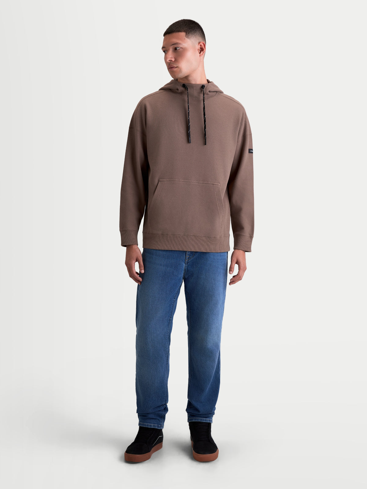 Alpinestars Camino Textured Oversized Hoodie, heren-sportswear pullover, bruin, gemaakt van gestructureerde knit twill fleece met een hoge kraag, trekkoorden en een kangoeroezak in een relaxte oversized pasvorm.