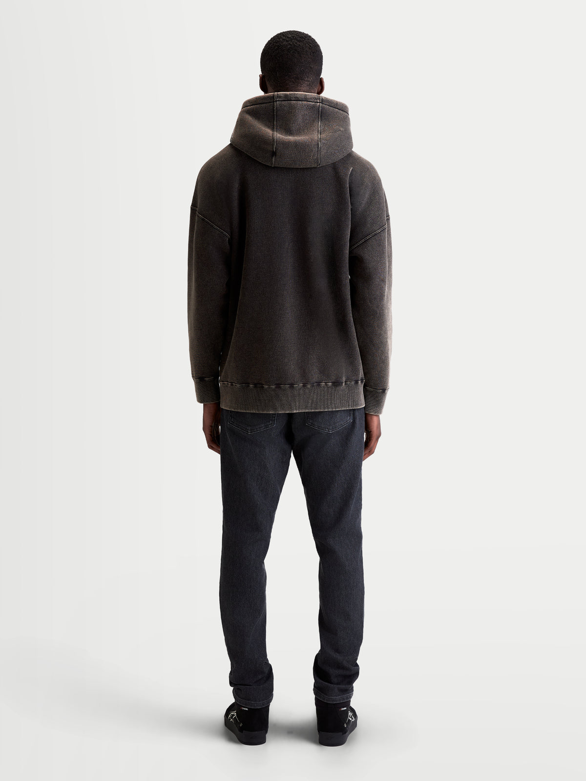 Alpinestars Infinite Washed Oversized Hoodie, casual sportswear-pullover, unisex, zwart, zachte fleece met snow-wash-afwerking, achteraanzicht met ontspannen pasvorm, capuchondetail en geribde zoom.