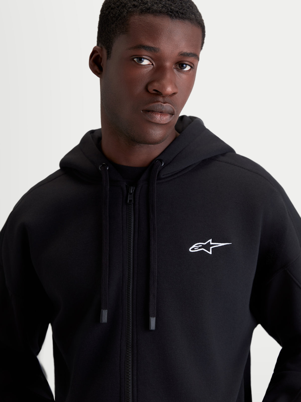 Alpinestars Entity Oversized Hoodie, heren sportswear fleecehoodie met ritssluiting, zwart met wit geborduurd Astars-logo op de borst, relaxte oversized pasvorm, Vislon-rits aan de voorzijde, zelfgevoerde capuchon met platte trekkoorden, premium katoen en gerecycled polyester.