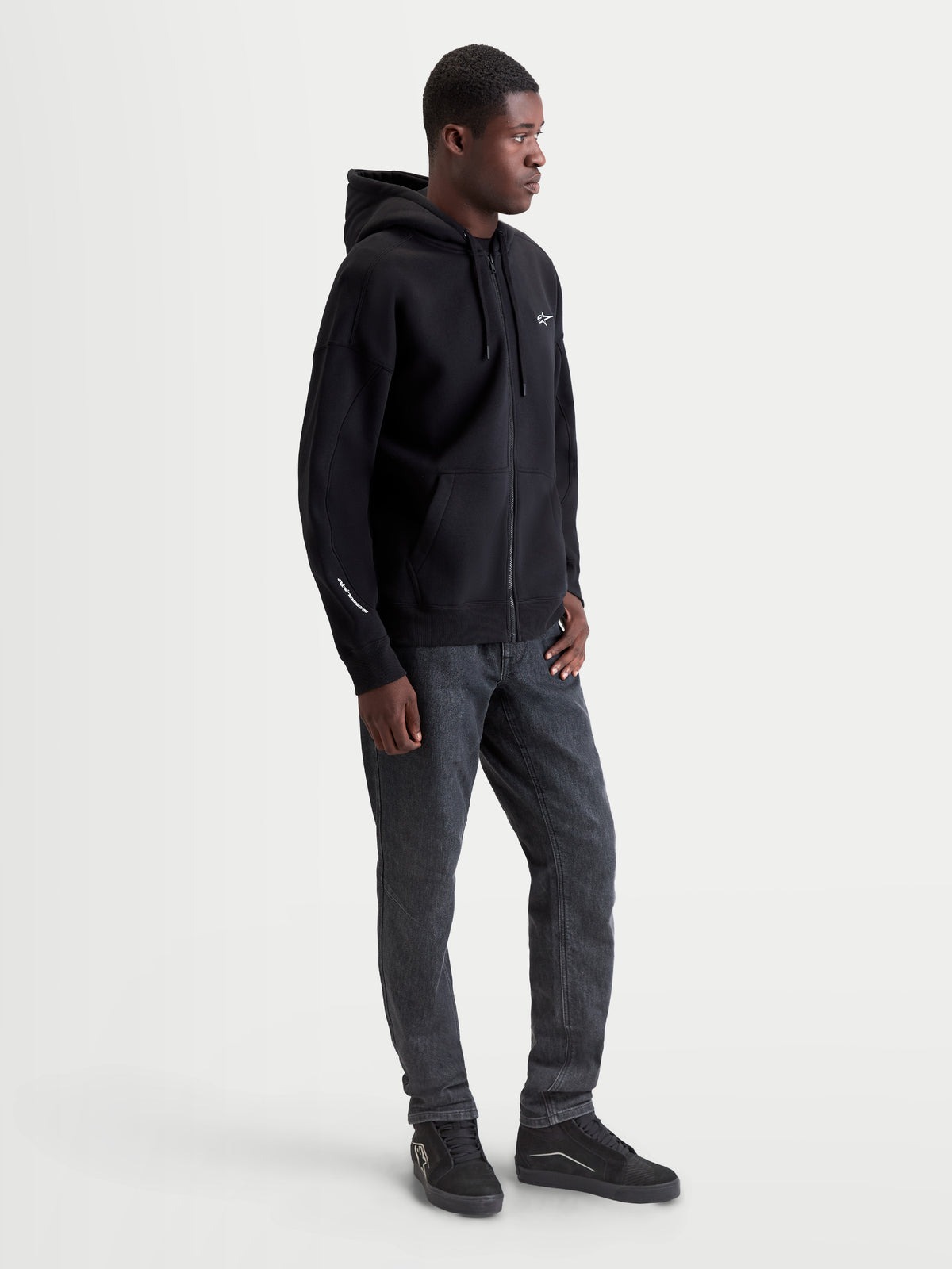 Alpinestars Entity Oversized Hoodie, heren-sportswear zip-fleece, zwart, oversized pasvorm, mix van katoen en gerecycled polyester, Vislon-rits aan de voorzijde, kangoeroezak en wit geborduurd logo op de borst en mouw.
