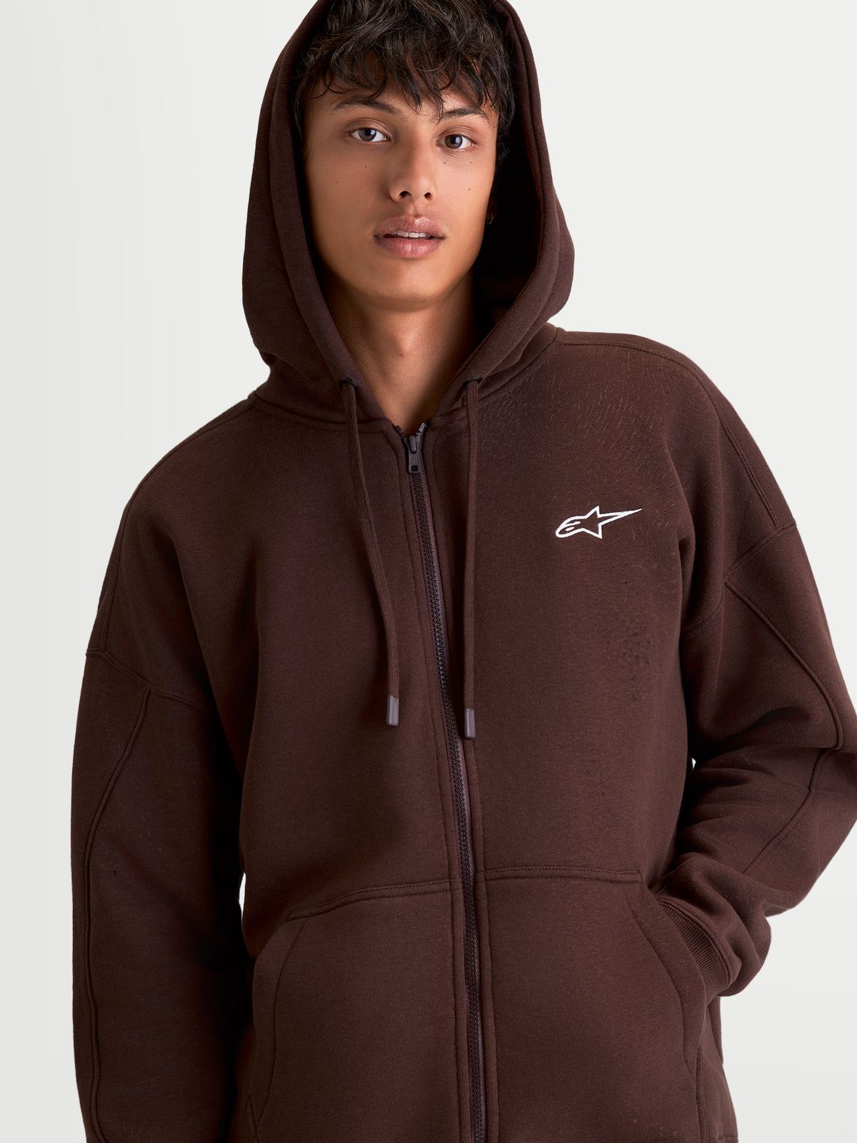 Alpinestars Entity Oversized Hoodie, bruine sportswear hoodie met ritssluiting voor heren, voorzien van een kangoeroezak en wit geborduurd Astars-logo op de borst, casual motorsportstijl.