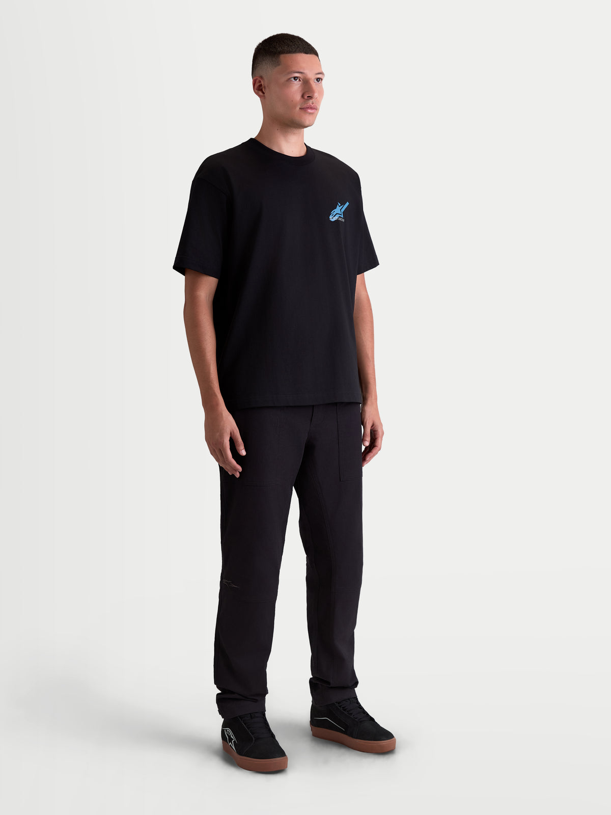 Alpinestars Ghost Oversized CSF t-shirt, sportswear-t-shirt met korte mouwen, unisex, zwart met blauwe logo-graphic, premium katoen-polyestermix, volledige weergave op model met een relaxte oversized pasvorm en motorsport-geïnspireerde esthetiek.