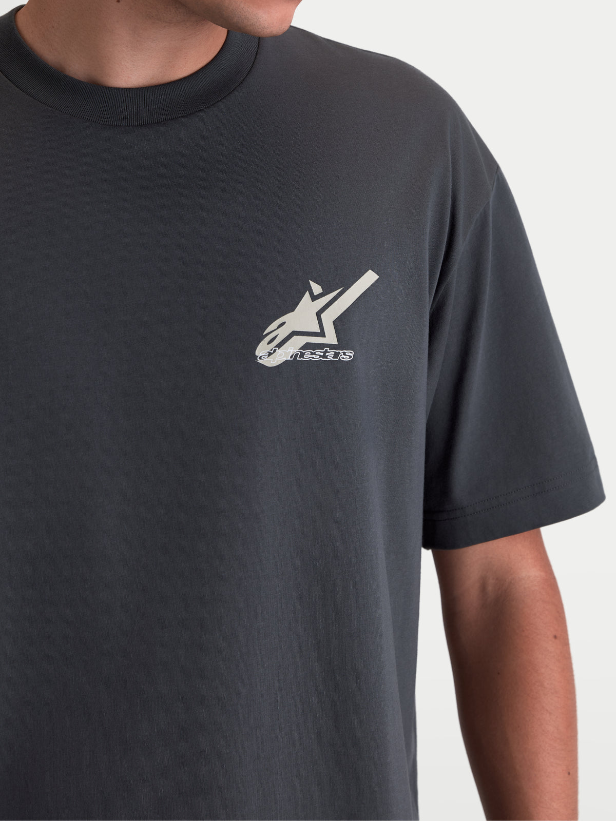 Alpinestars Ghost Oversized CSF T-shirt, sportswear T-shirt met korte mouwen, grijs, detailopname van het Astars-logo op de borst, relaxte oversized pasvorm, katoen-polyestermix, lifestyle detail op model.