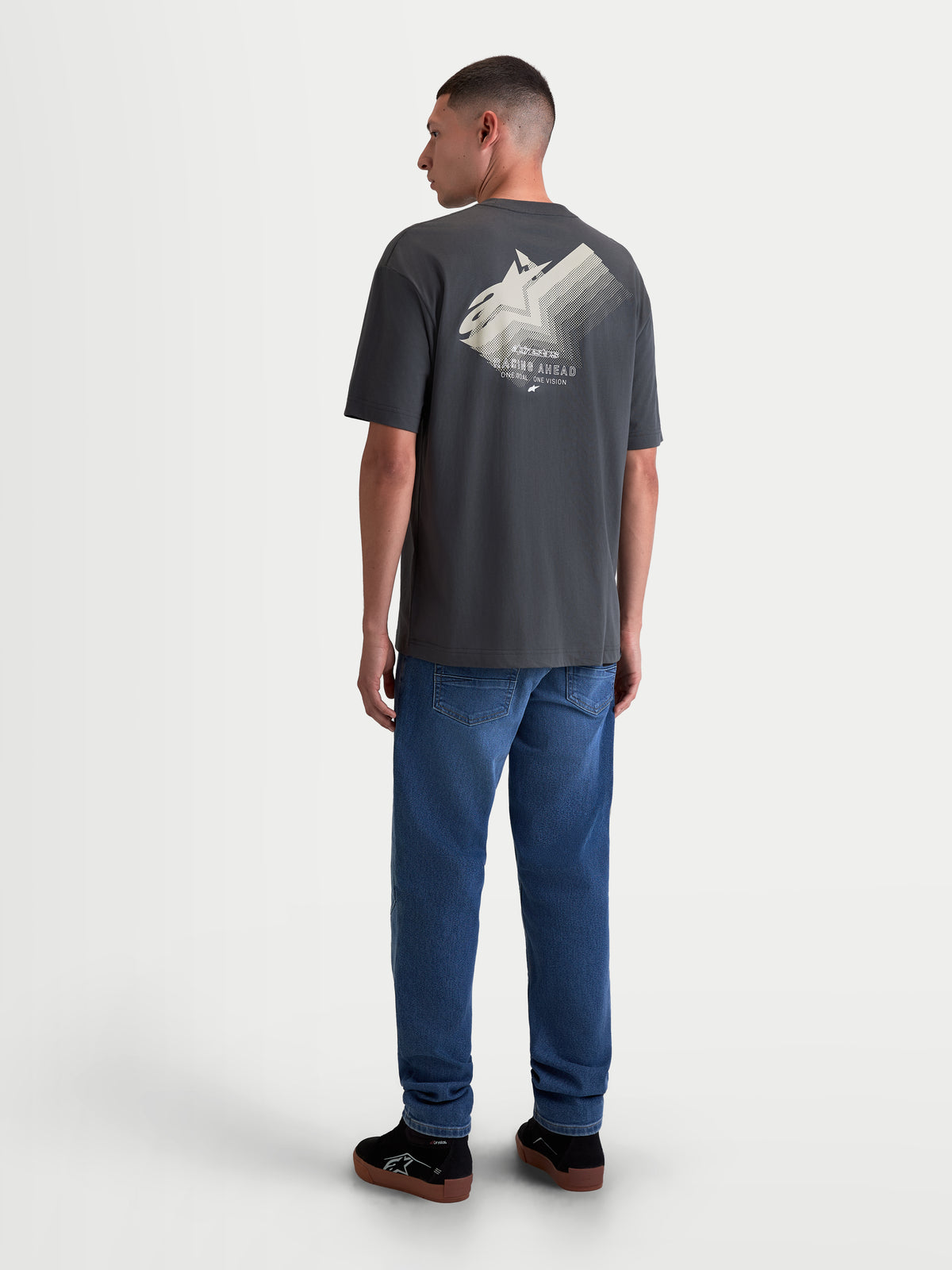 Alpinestars Ghost Oversized CSF T-shirt, heren sportswear t-shirt met korte mouwen, antracietgrijs, achteraanzicht met grote Astars-logo fade-graphic en 'Racing Ahead' tekst, relaxte oversized pasvorm voor dagelijks gebruik.