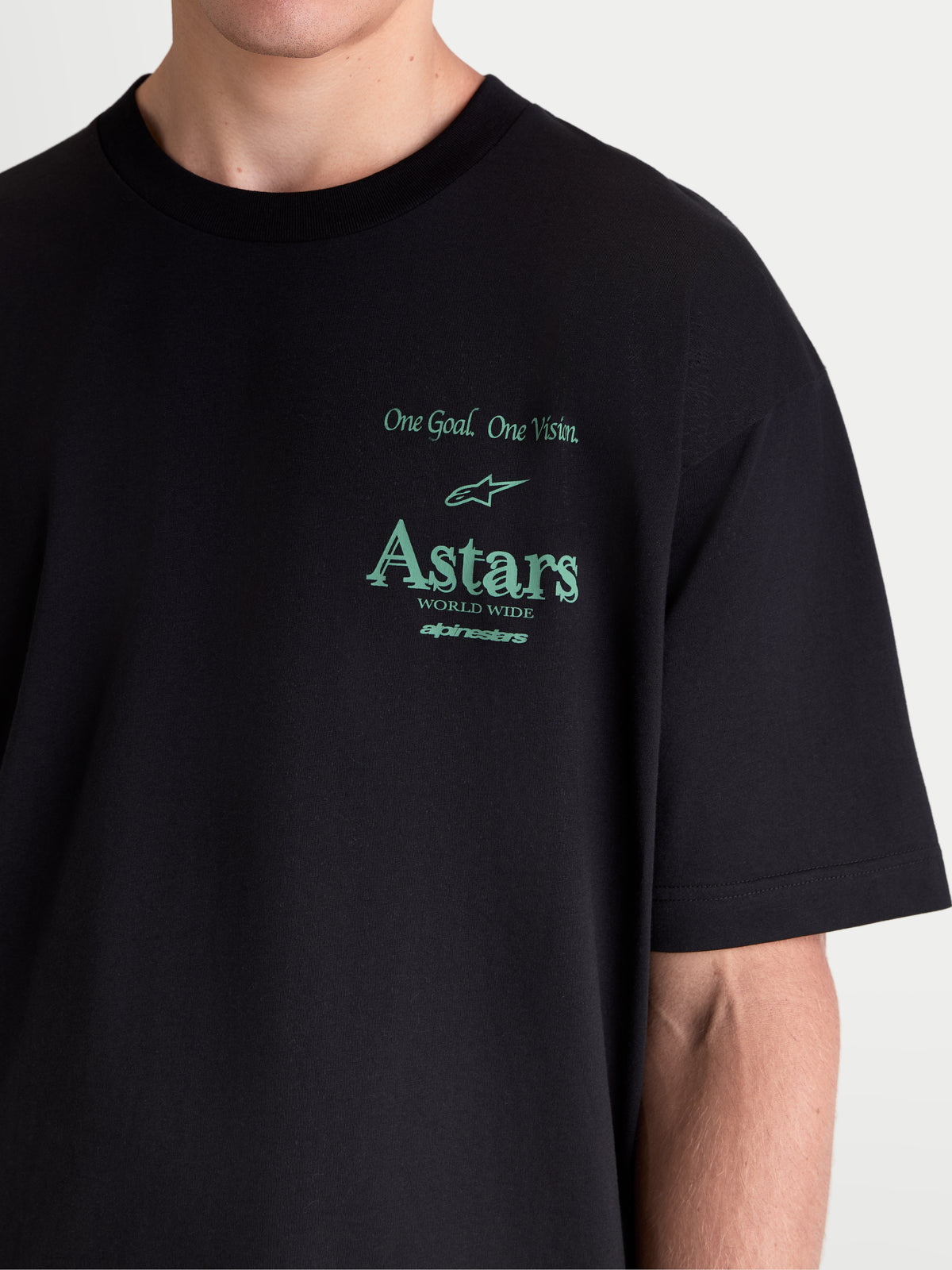 Alpinestars Post Oversized CSF t-shirt, sportswear t-shirt met korte mouwen, zwart met groene graphics, voorzien van 'One Goal. One Vision.' en Astars-branding, close-up op model met oversized fit en premium katoenmix constructie.