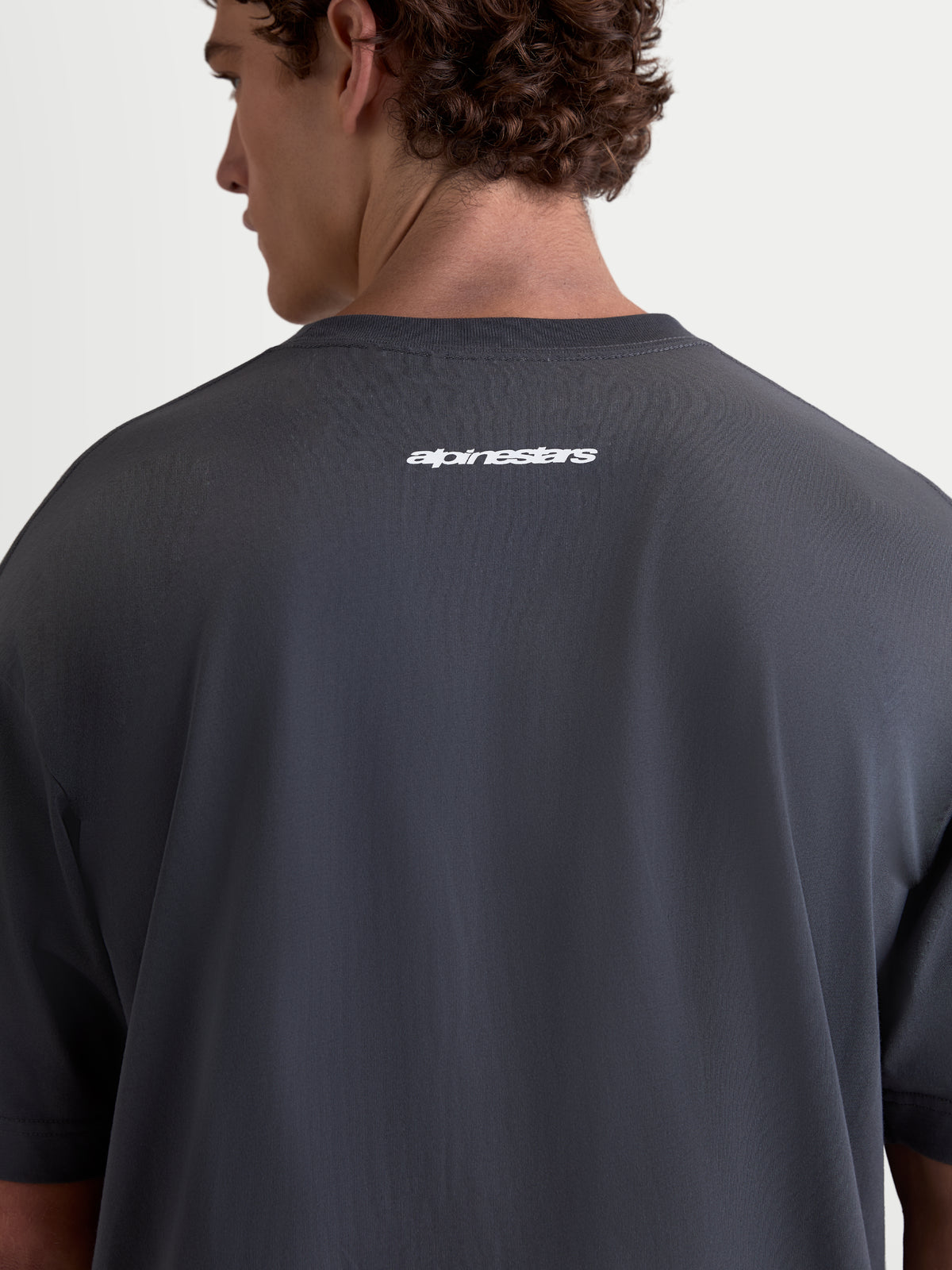 Alpinestars Prelude Oversized CSF t-shirt, grijs sportswear-t-shirt met korte mouwen, achteraanzicht op model met wit Alpinestars-woordmerk op de rug, relaxed oversized pasvorm, katoen-polyestermix.