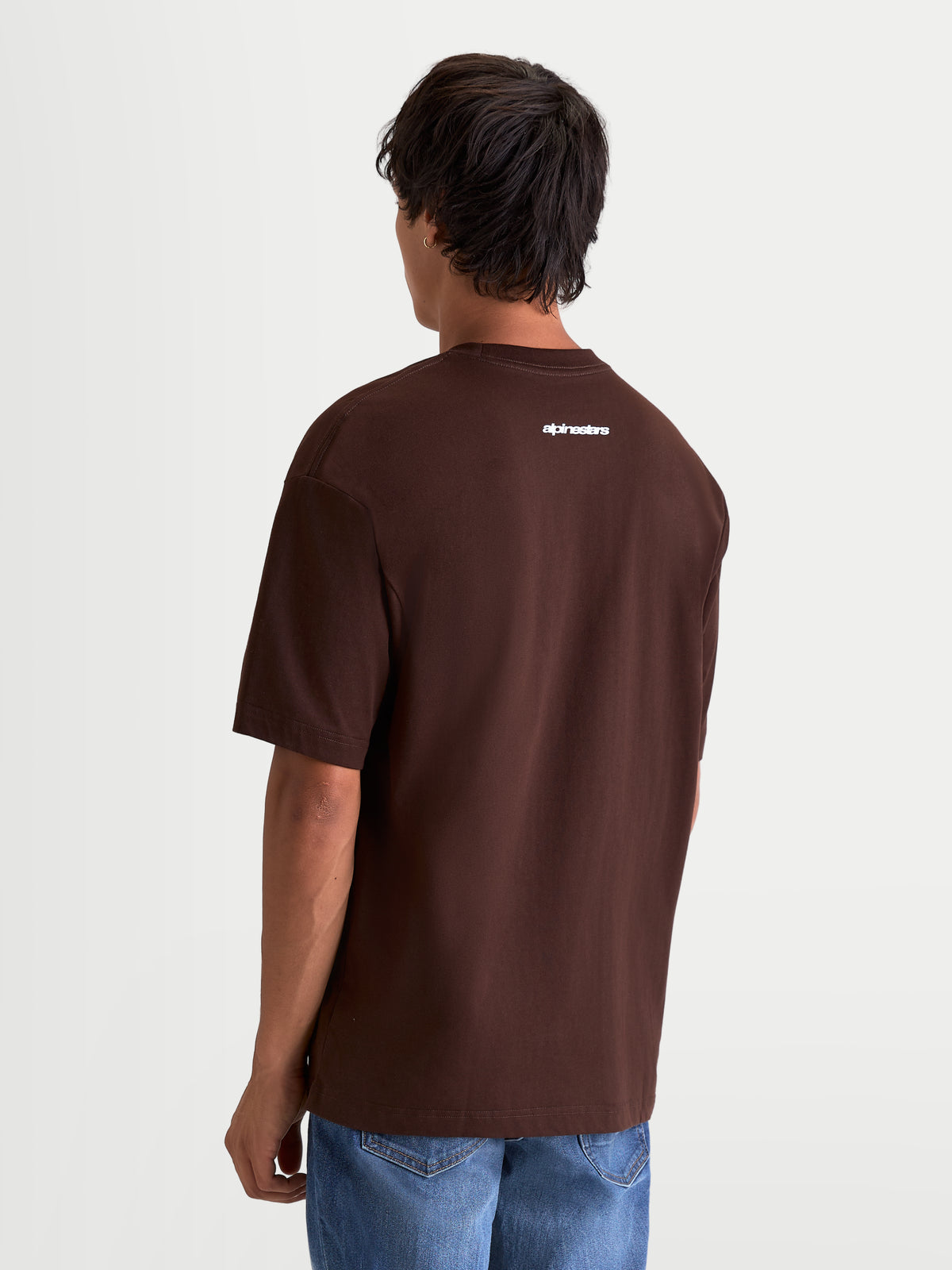 Alpinestars Prelude Oversized CSF T-shirt, bruin t-shirt met korte mouwen, achteraanzicht op model met wit Alpinestars-woordmerk op de bovenrug, relaxed oversized pasvorm, casual sportswear.
