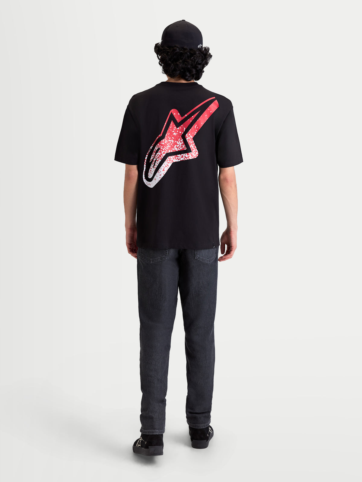 Alpinestars Meteor CSF t-shirt met korte mouwen, zwart, achteraanzicht op model met een groot Astars-logo op de rug voorzien van een rood en wit MX-kleurverloop, casual sportswear.