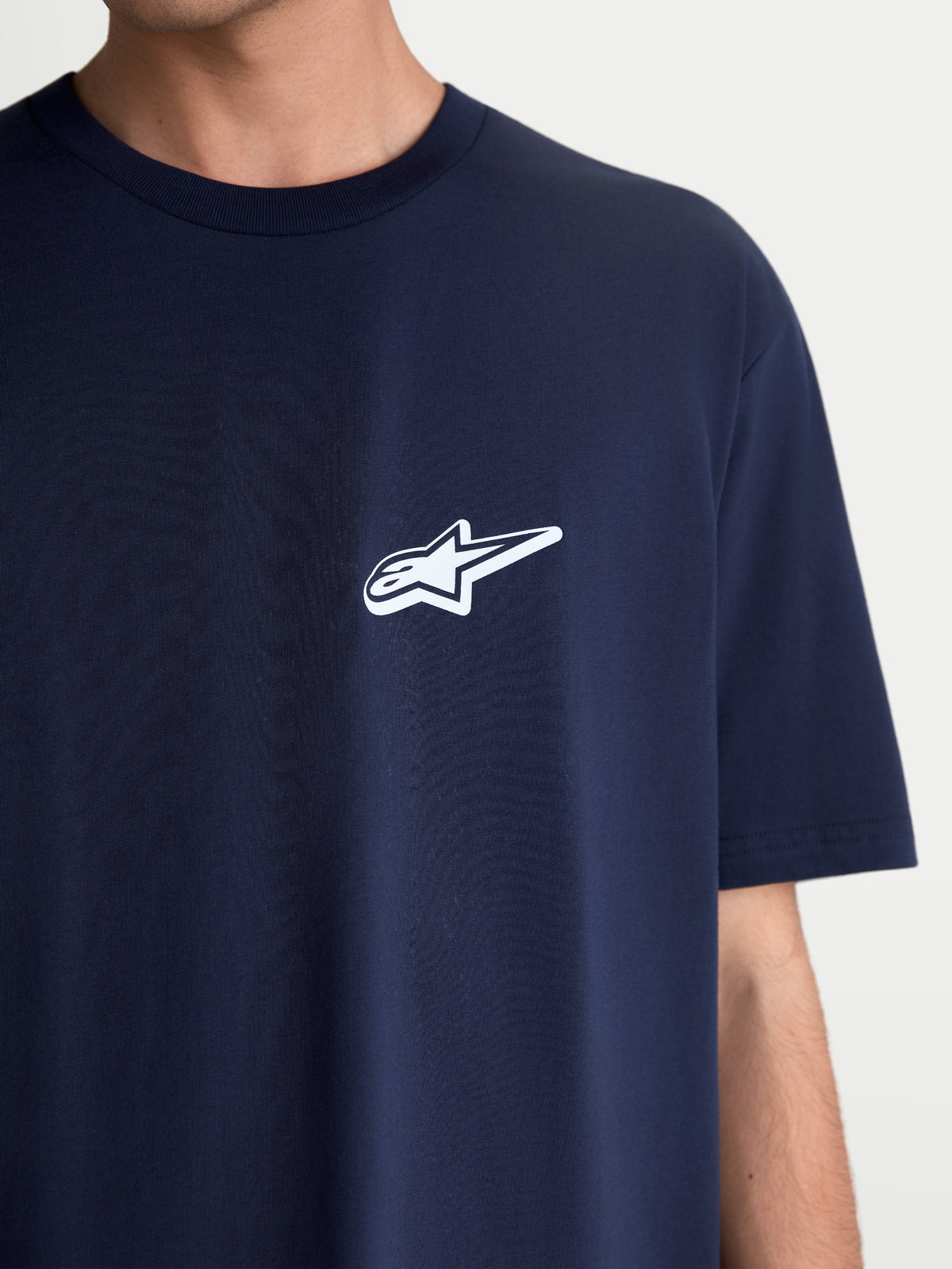 Alpinestars Meteor CSF T-shirt, sportswear t-shirt met korte mouwen, donkerblauw met een wit Astars-logo op de borst, unisex casual motorsportkleding, zachte katoen-polyestermix, close-up op model.