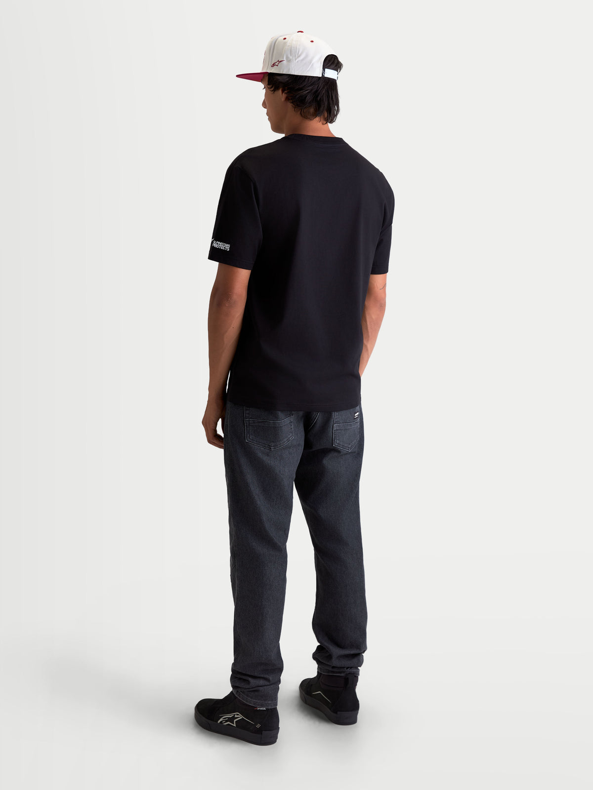 Alpinestars P1 CSF t-shirt, heren sportswear t-shirt met korte mouwen, zwart, achteraanzicht op een model, kleine grafische opdruk op de mouw, zachte katoen-polyestermix, casual motorsportstijl