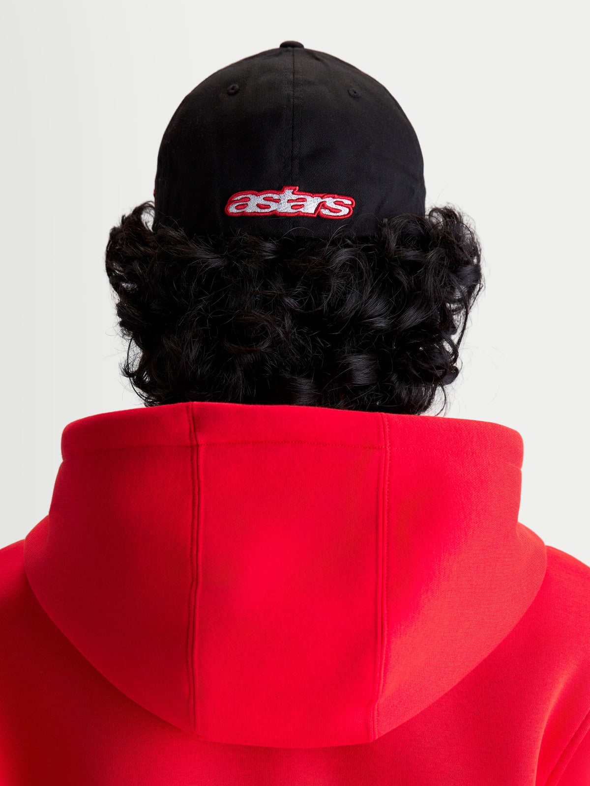Alpinestars Lineout pet, sportswear baseballpet, zwart en rood, achteraanzicht op model met geborduurd astars-logo, gestructureerde kroon, keperstof constructie.