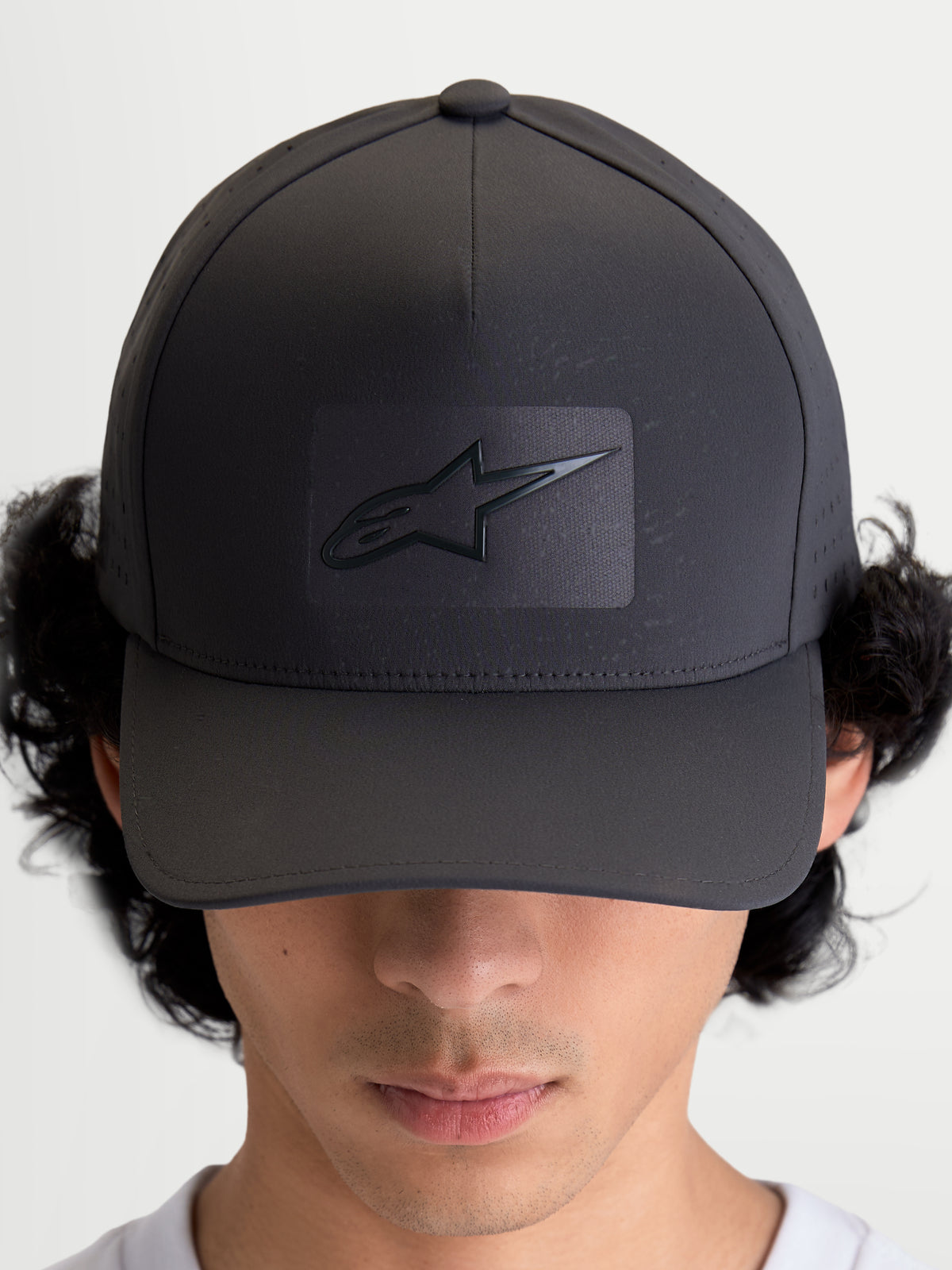 Alpinestars Algo Perf verstelbare pet, sportswear baseballpet, donkergrijs, voorzien van een gestructureerde kroon, gebogen klep en sonic-weld Astars-logo met ademende zijperforaties, vooraanzicht op model.