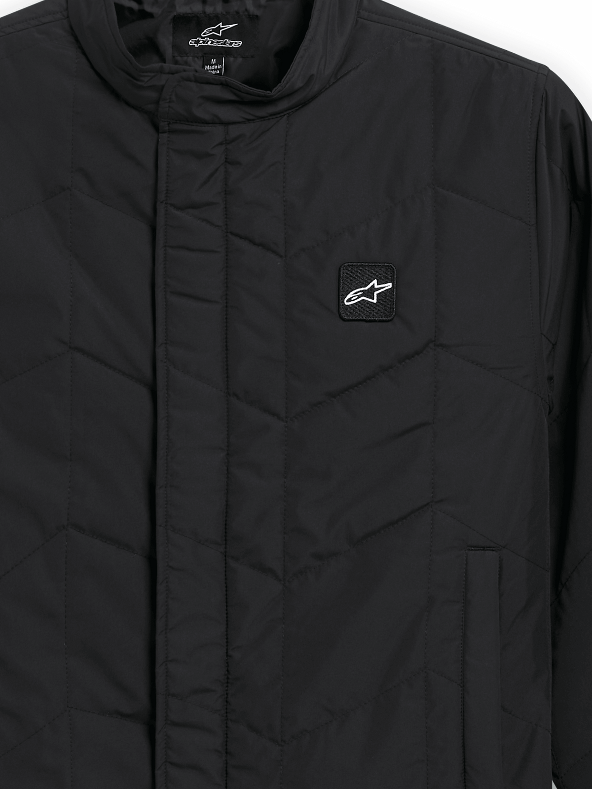 Alpinestars Precedent Jacket, Quilted Sportswear Jacket, Black, close-up view featuring an iconic angled quilt pattern, low track collar, covered front zipper, and small chest logo patch