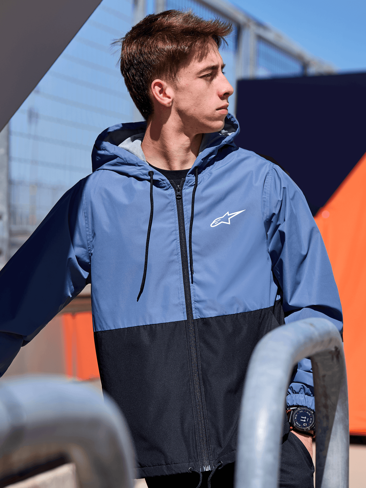 Alpinestars Speeder Windbreaker jas, lichtgewicht windbreaker met capuchon, Slate Blue en zwart kleurblokontwerp, wit Alpinestars-logo op de borst, mesh-gevoerd met trekkoord bij de capuchon, casual motorsport-geïnspireerde streetwear