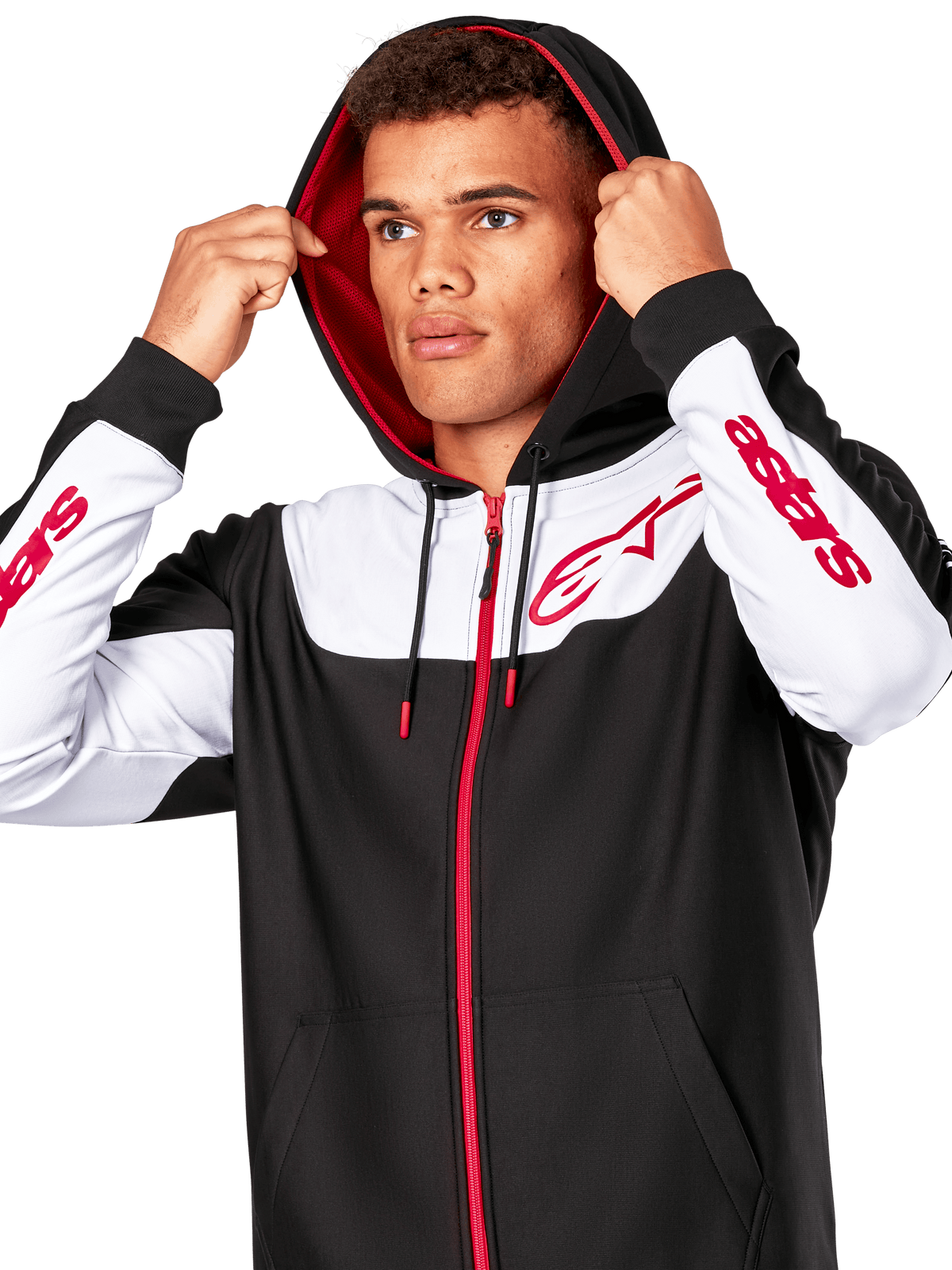 Alpinestars Sessions V3 Hoodie, zwart wit en rood, hoodie met ritssluiting gedragen door een man met de capuchon op, rode Alpinestars-logo's op de borst en mouwen, casual motorsport streetwear