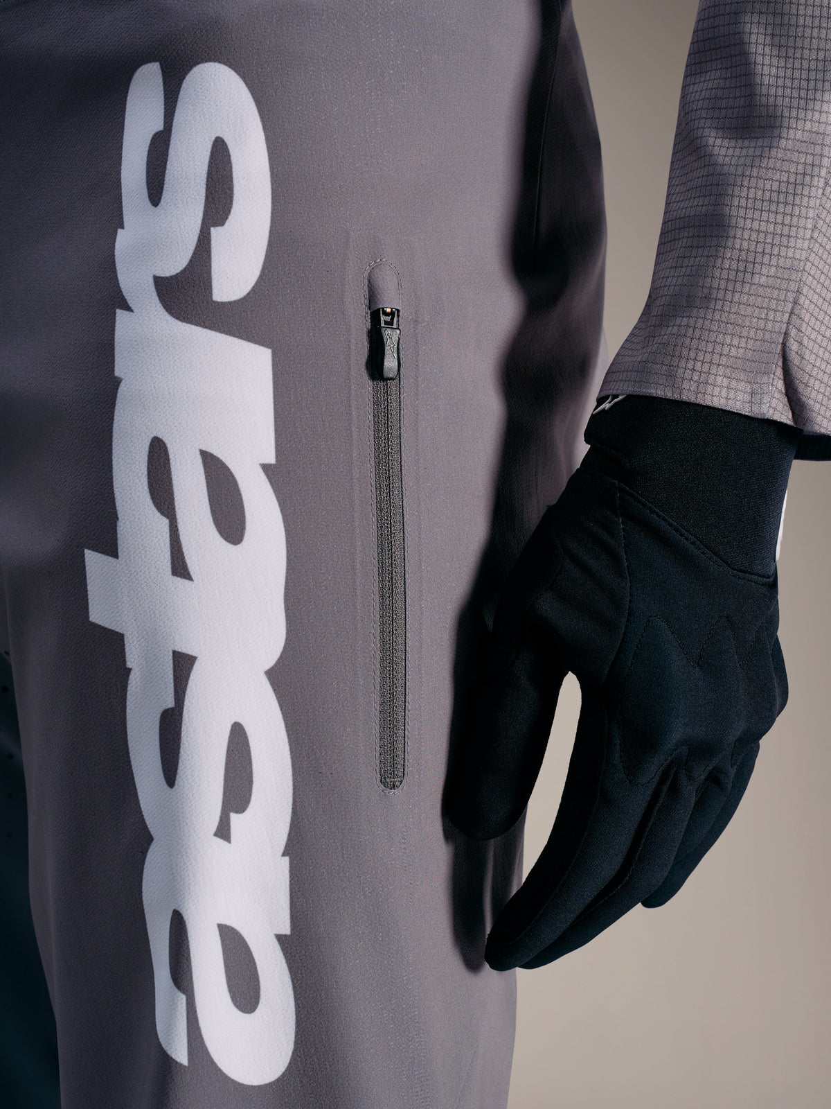 A-Supra Elite broek in Faded Gray met opvallend wit logo en verticale ritszak, ontworpen voor MTB-raceprestaties.