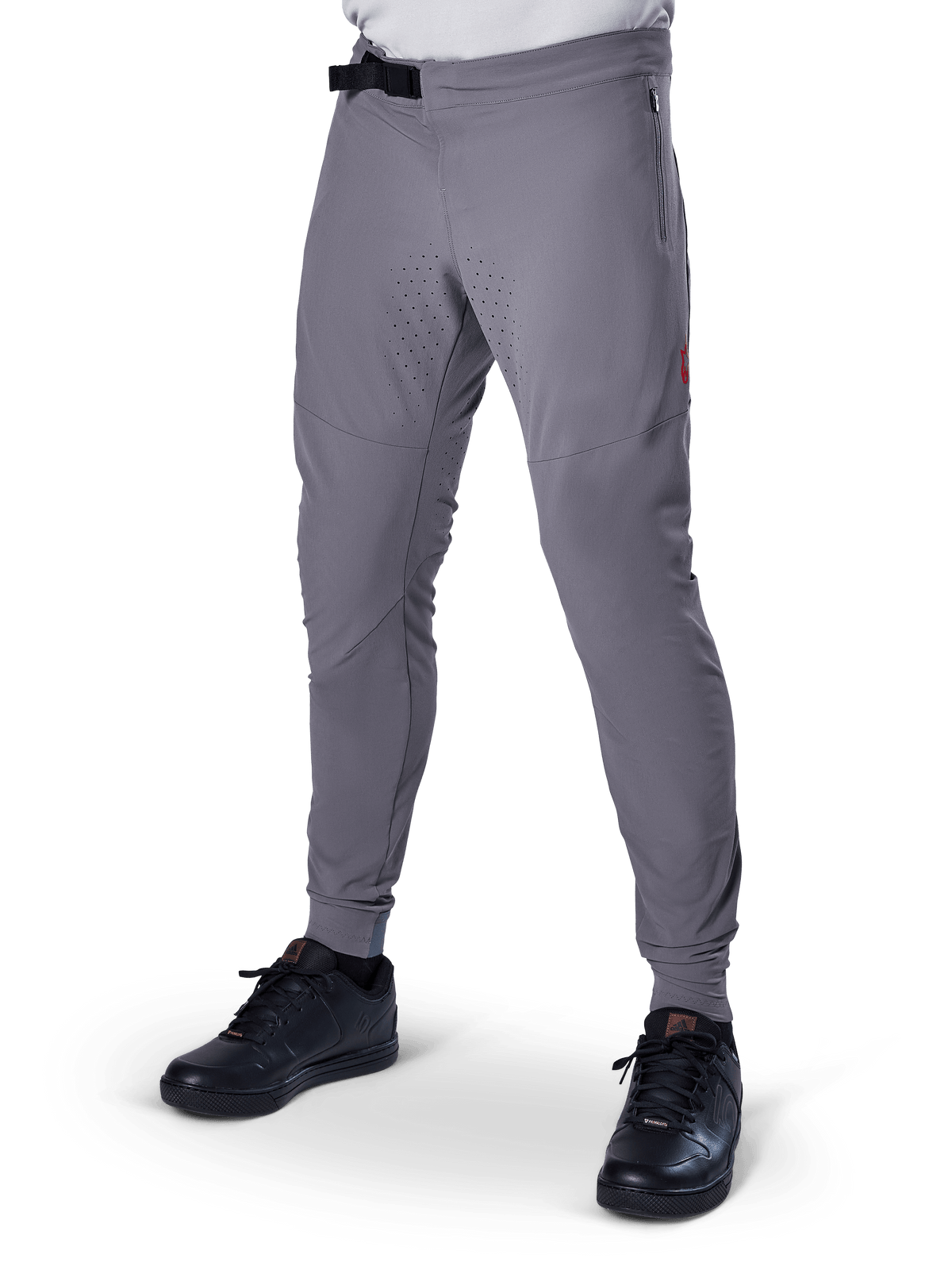 Alpinestars A-Aria Elite Pants, Dark Gray MTB Pants, laser perforated panels on thighs, black magnetic buckle closure, zippered pocket, red logo detail, slim performance fit, worn with black shoes