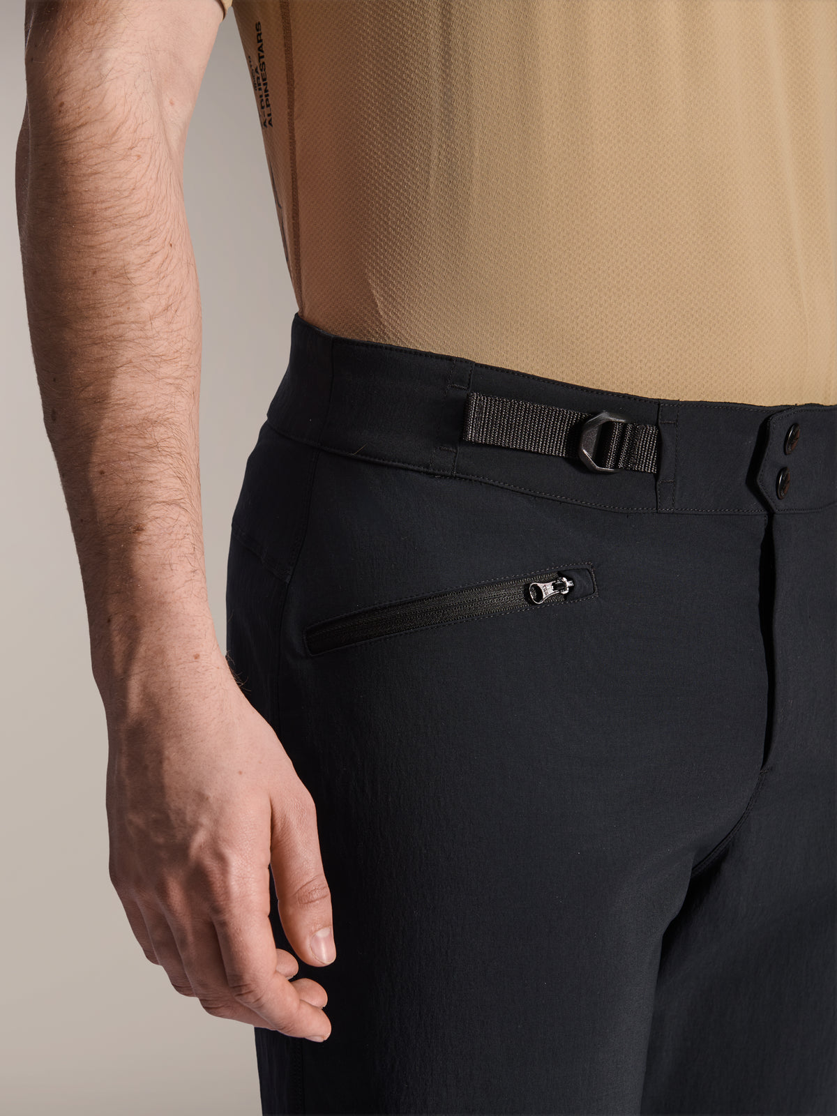 Alpinestars A-Dura Shorts, zwarte MTB-shorts, close-up weergave met zak met ritssluiting en verstelbare zijdelingse tailleversteller, dubbele drukknoopsluiting, duurzame stof voor mountainbiken