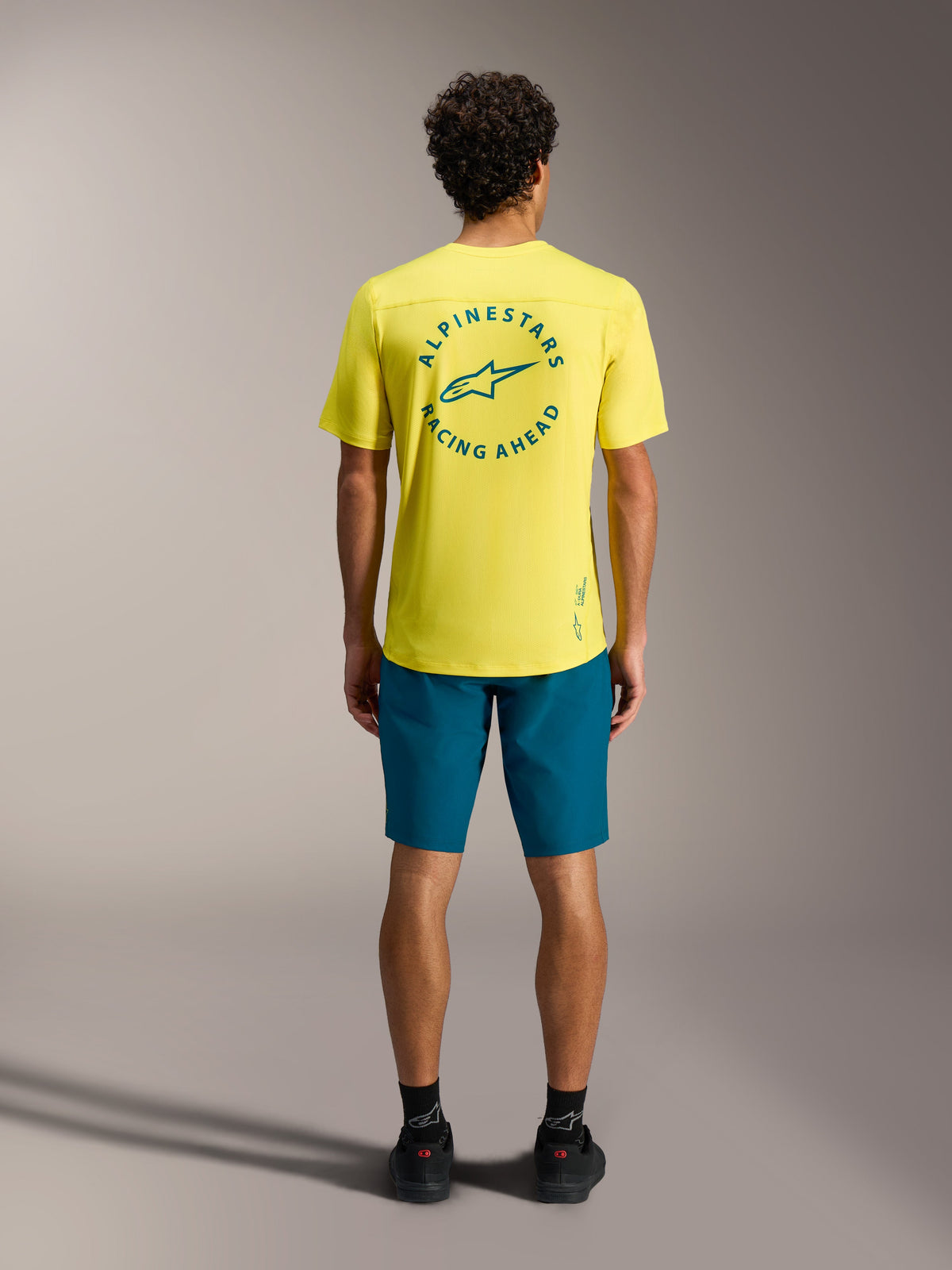 Gele A-Dura Air SS Jersey met groenblauw ruglogo en blauwgroene A-Dura Ride shorts, professionele MTB-kleding.