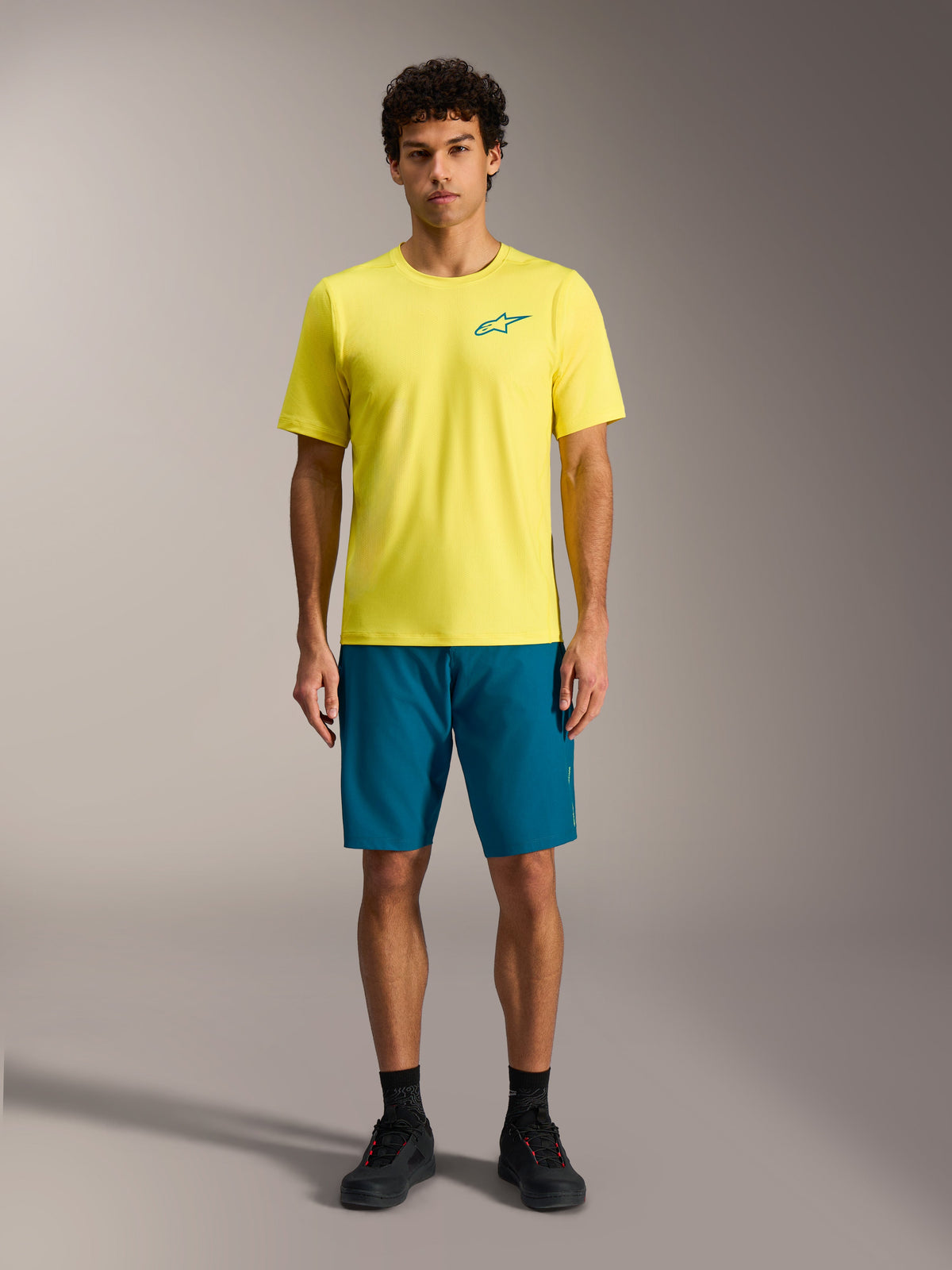 Gele Alpinestars A-Dura Air SS Jersey en blauwgroene A-Dura Ride Shorts, performance MTB-outfit voor heren.