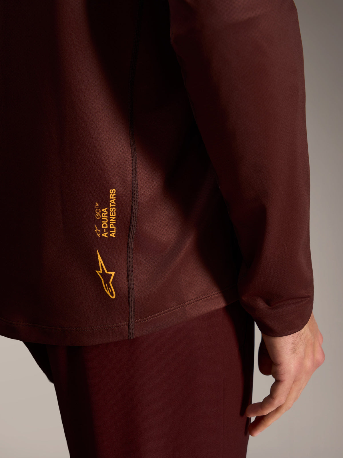 A-Dura Ride Long Sleeve Jersey in Bordeaux, featuring yellow Alpinestars logo branding on textured performance fabric.