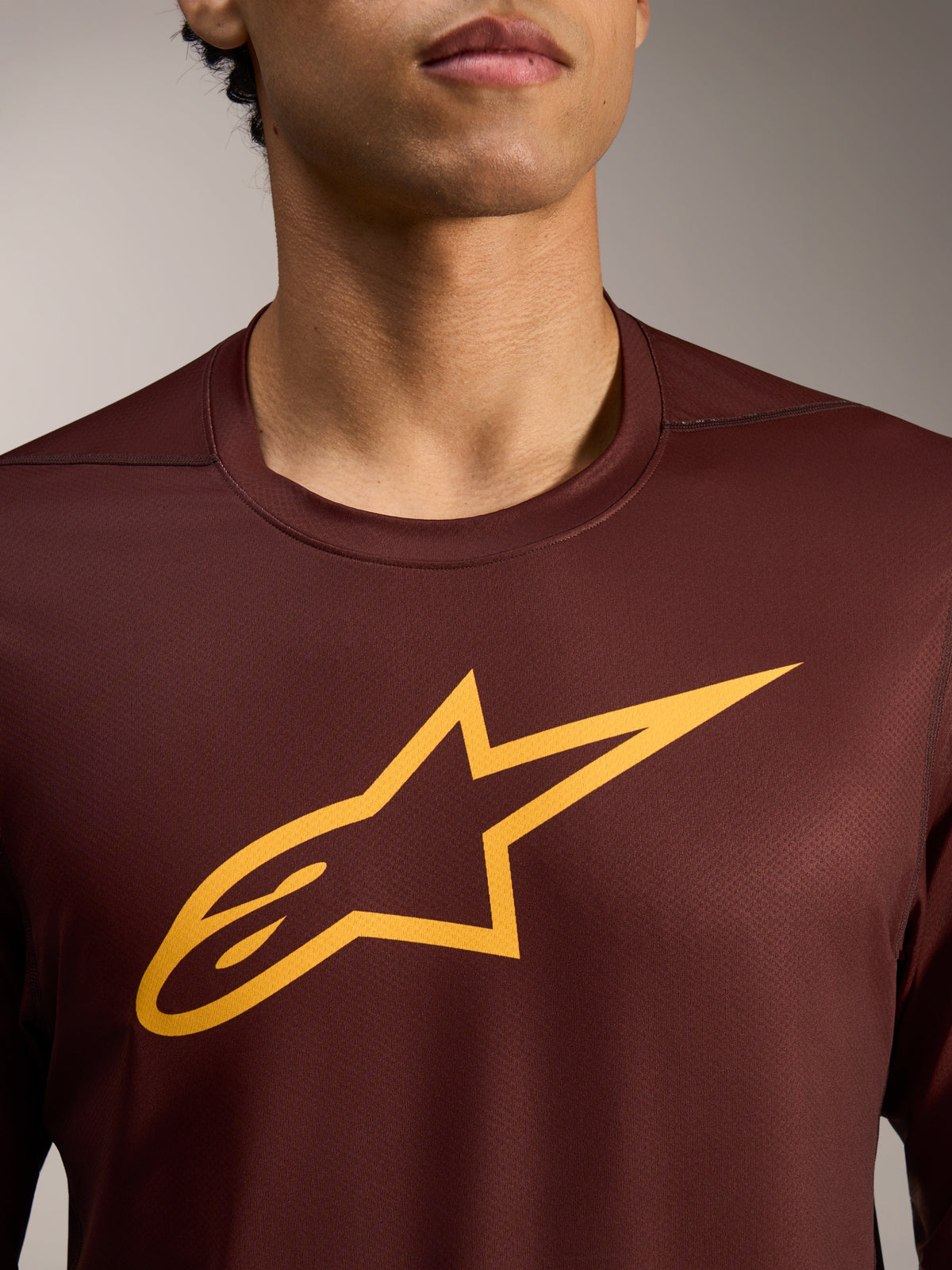 A-Dura Ride Long Sleeve Jersey in Bordeaux with a bold yellow Astars logo graphic on the performance jacquard fabric.